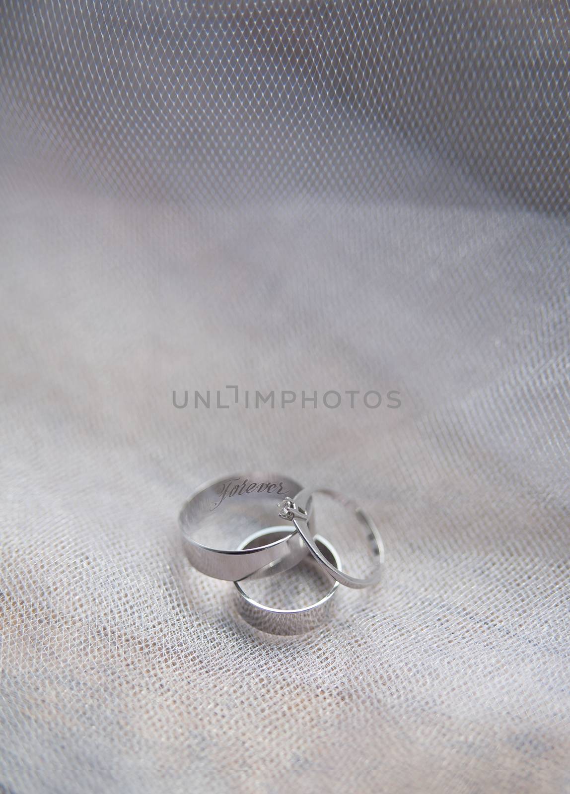 Platinum engagement and wedding ringson on fabric background.