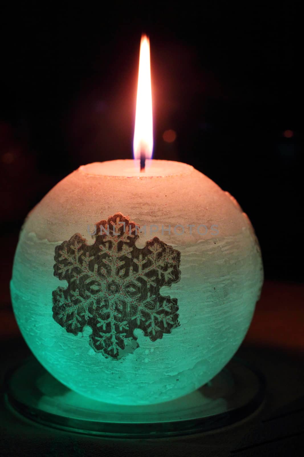 Glowing candle with a diode and snowflake lights up in the dark
