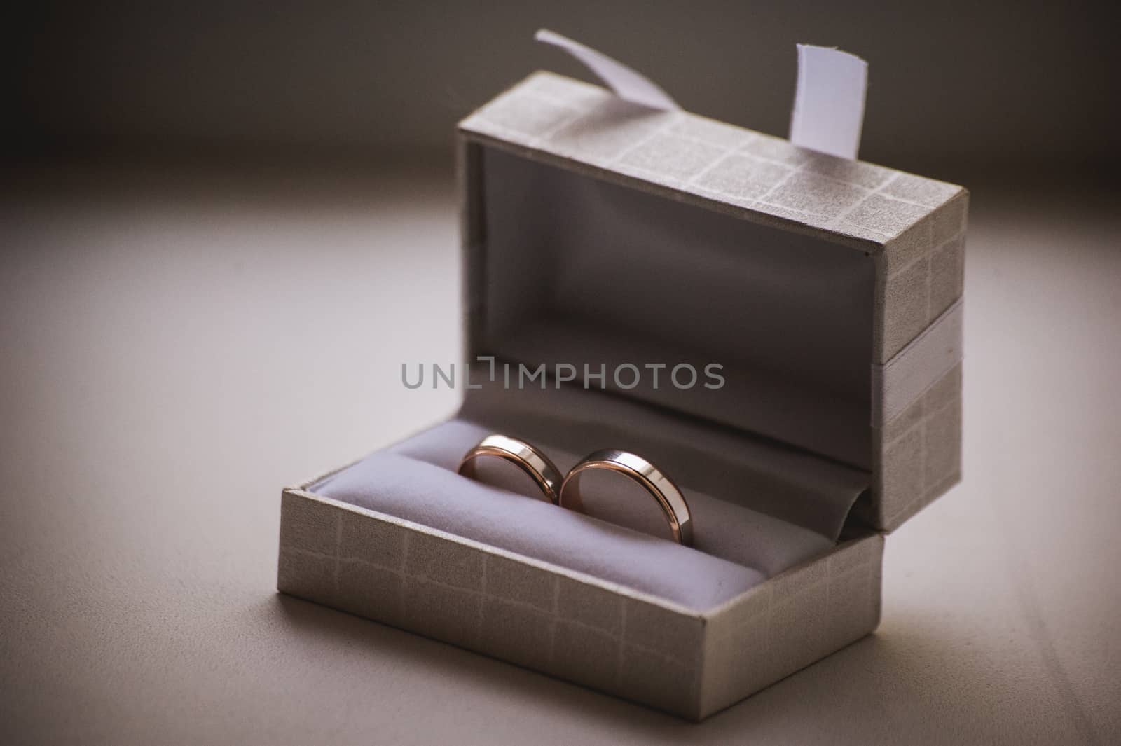 two wedding rings in grey box with bow