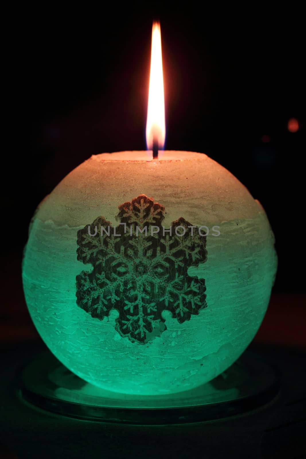Glowing candle with a diode and snowflake lights up in the dark