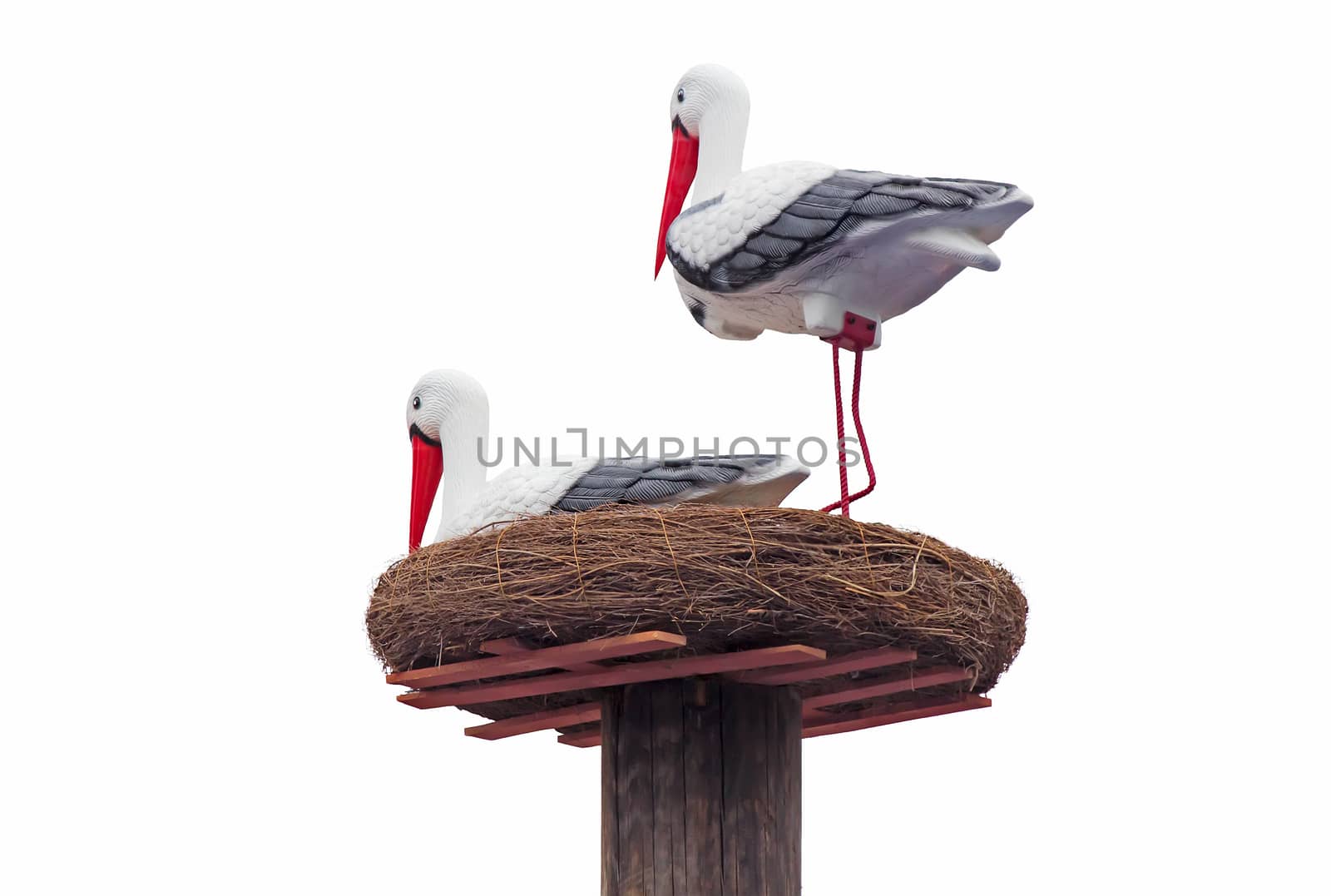 Two sculptures of storks in the nest. Presented on a white background.