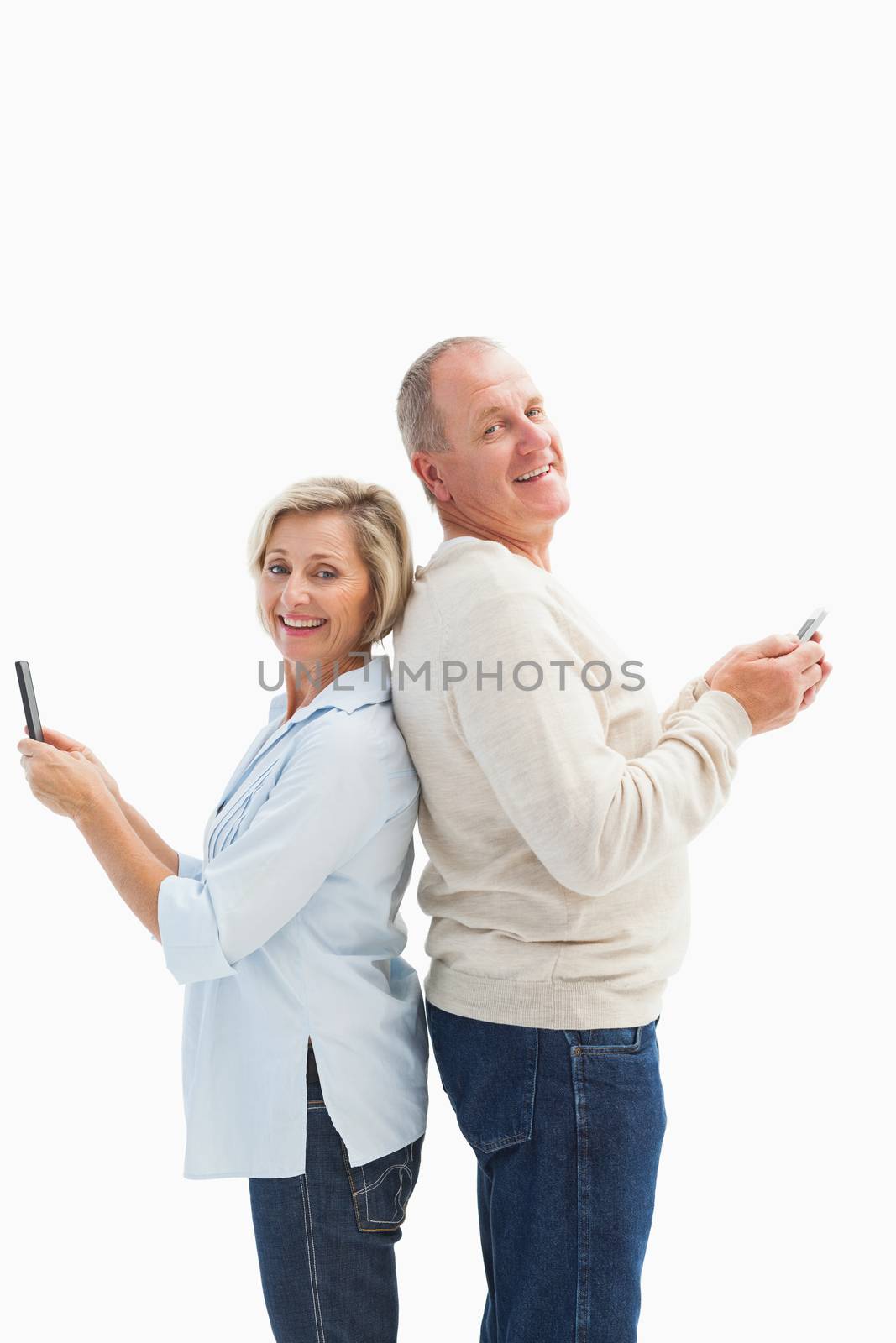 Happy mature couple using their smartphones by Wavebreakmedia