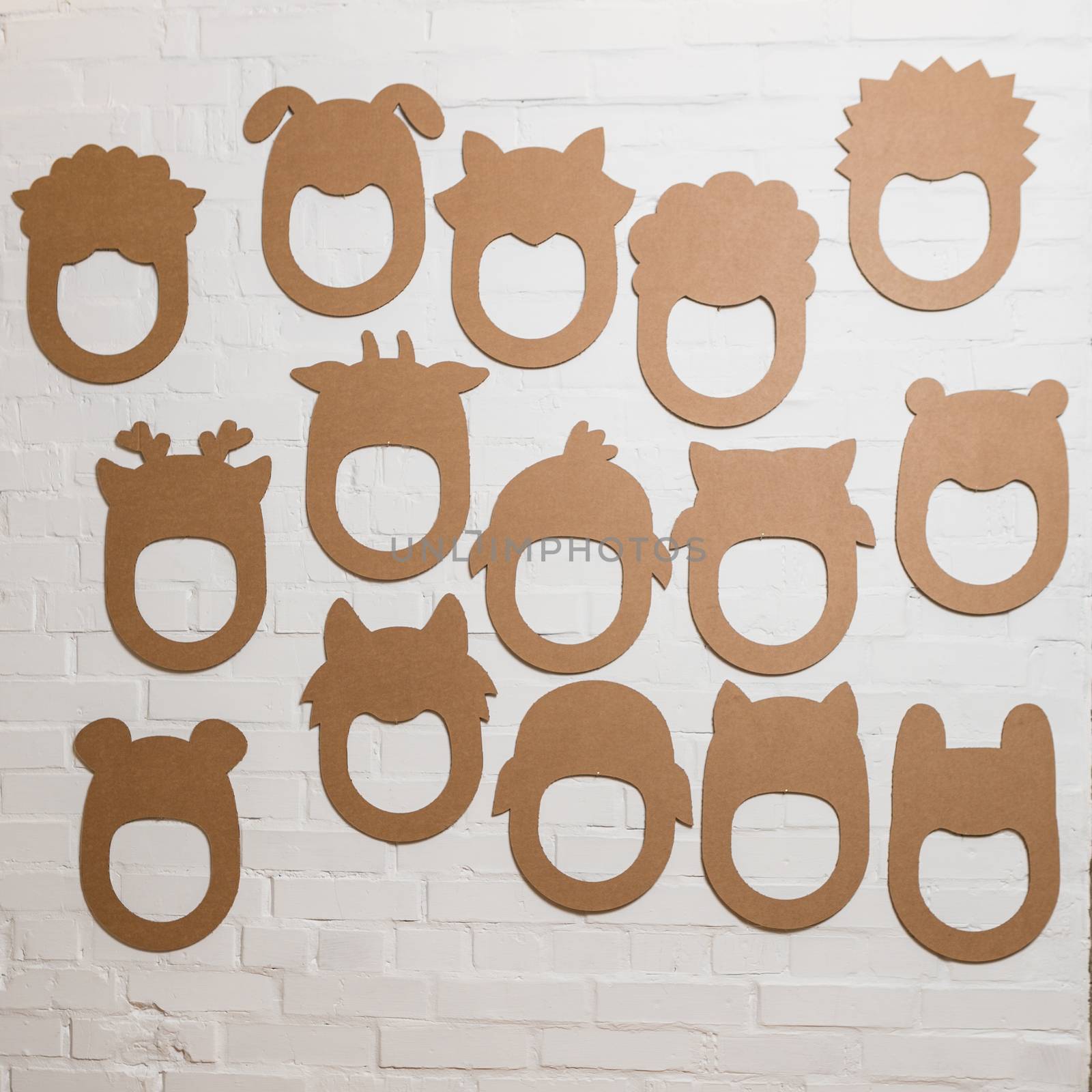 Set of cardboard masks on a white brick wall. Consept card.