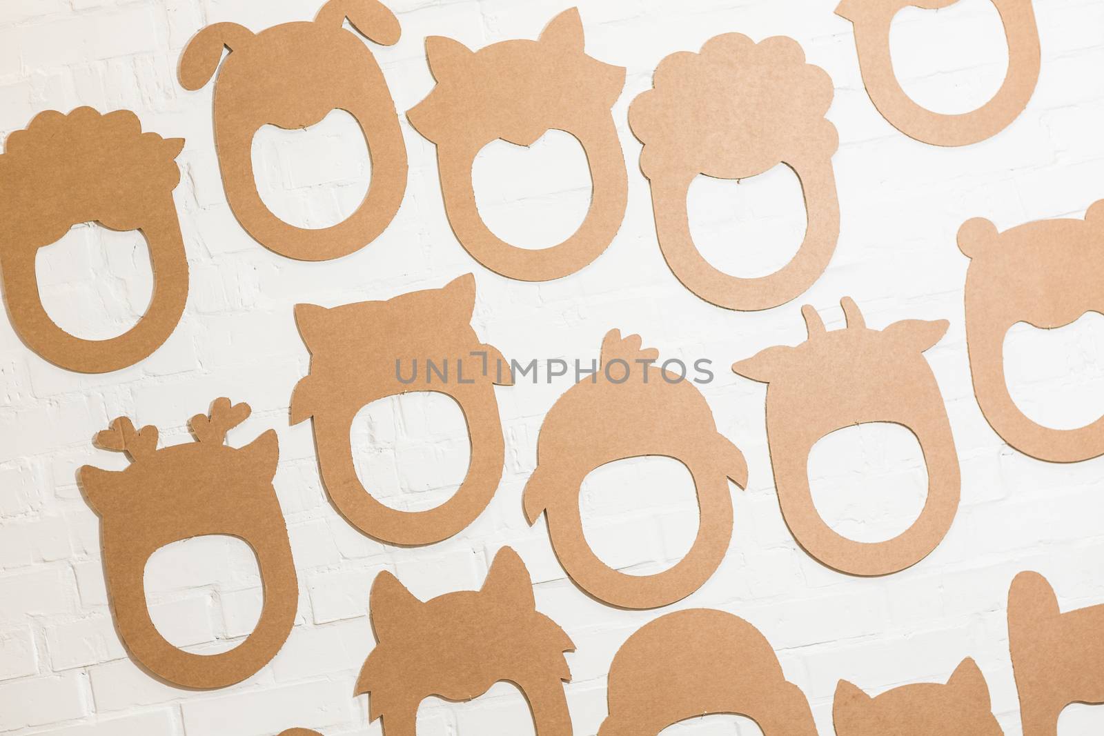 Set of cardboard masks on a white brick wall. Consept card.