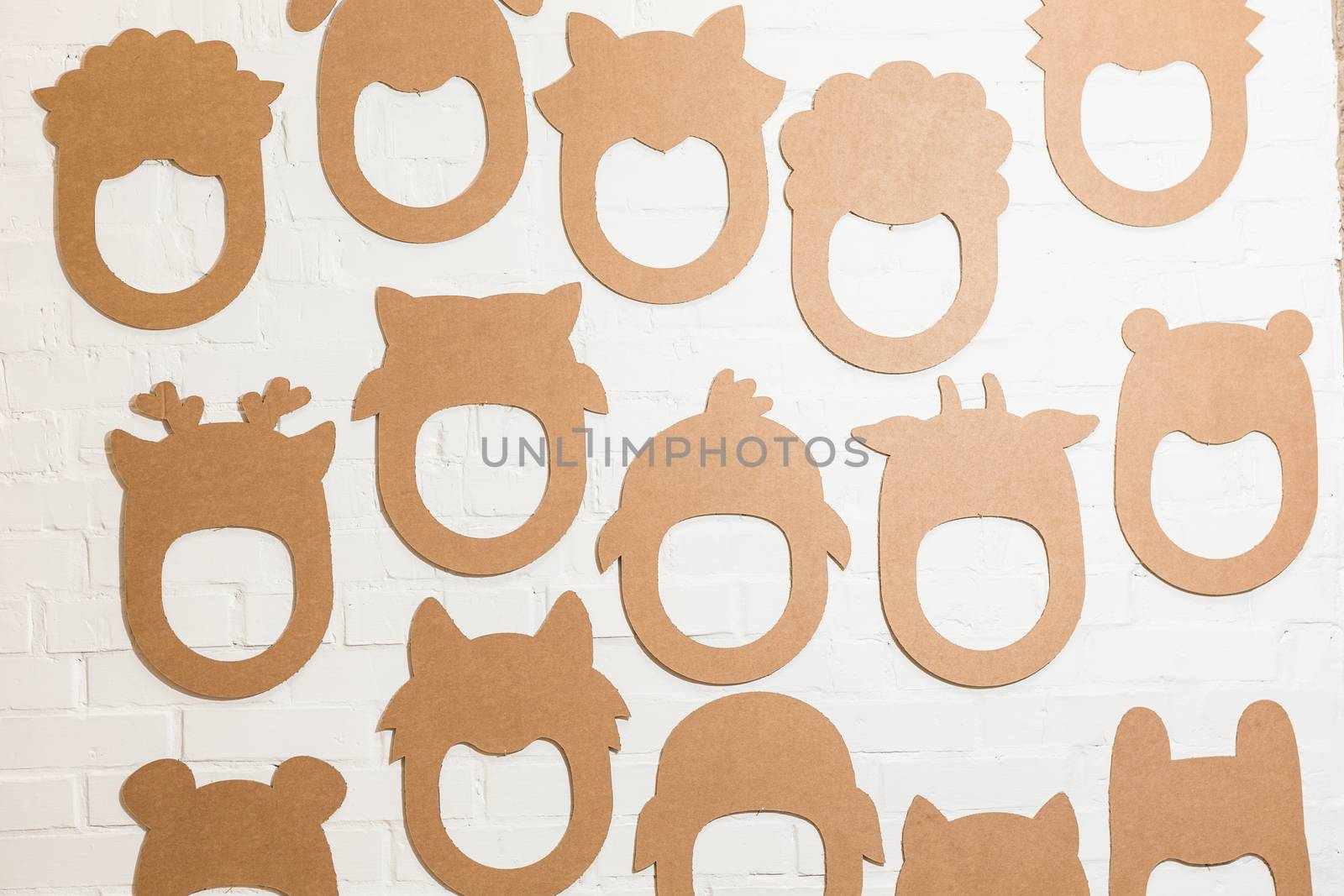 Set of cardboard masks on a white brick wall. Consept card.