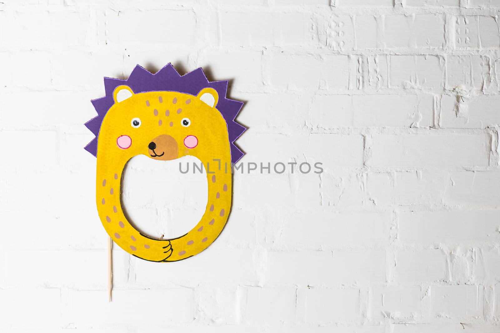 Bright cardboard mask on a white brick wall. Consept card. Hedgehog