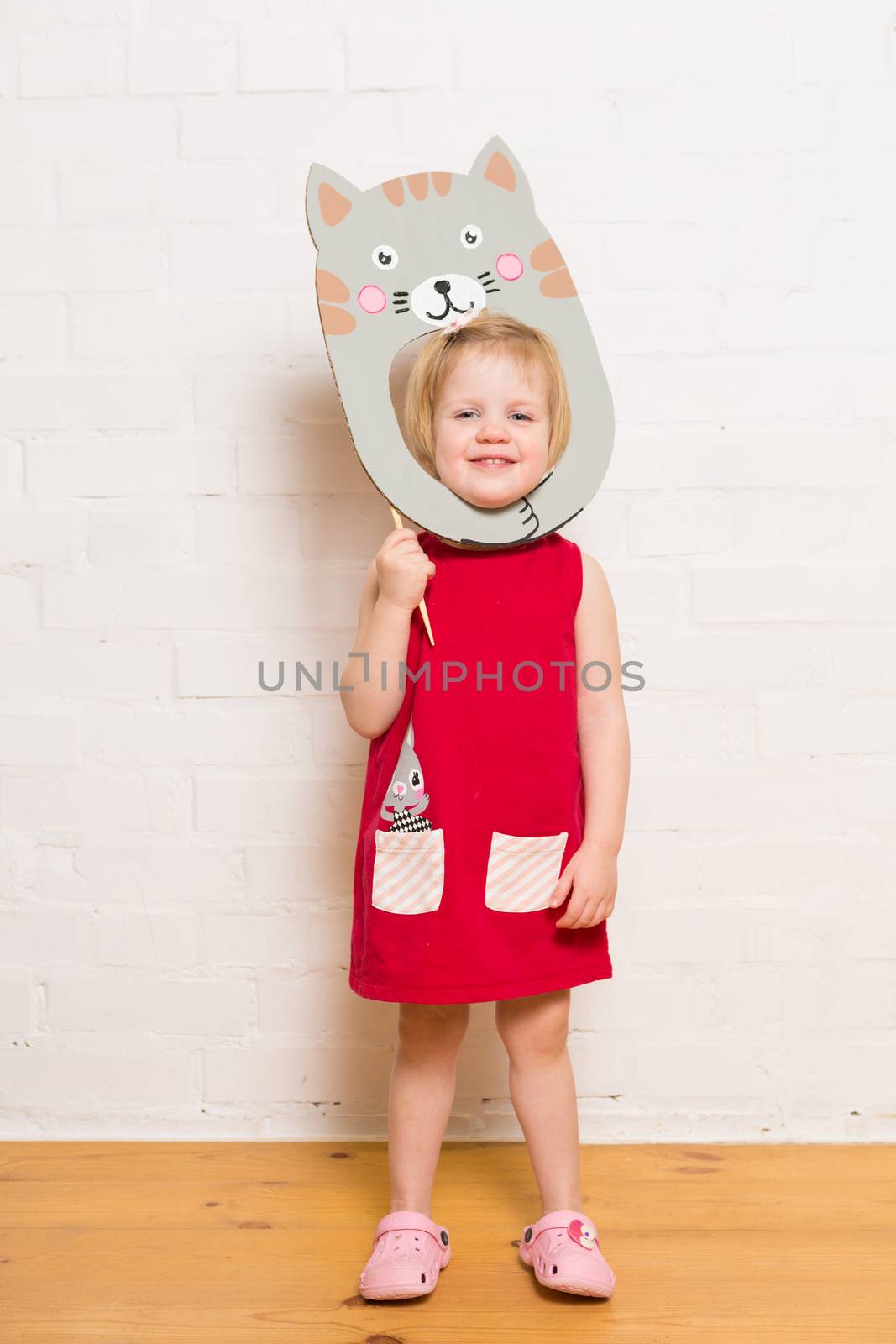 Little blonde girls holding cat mask on white background