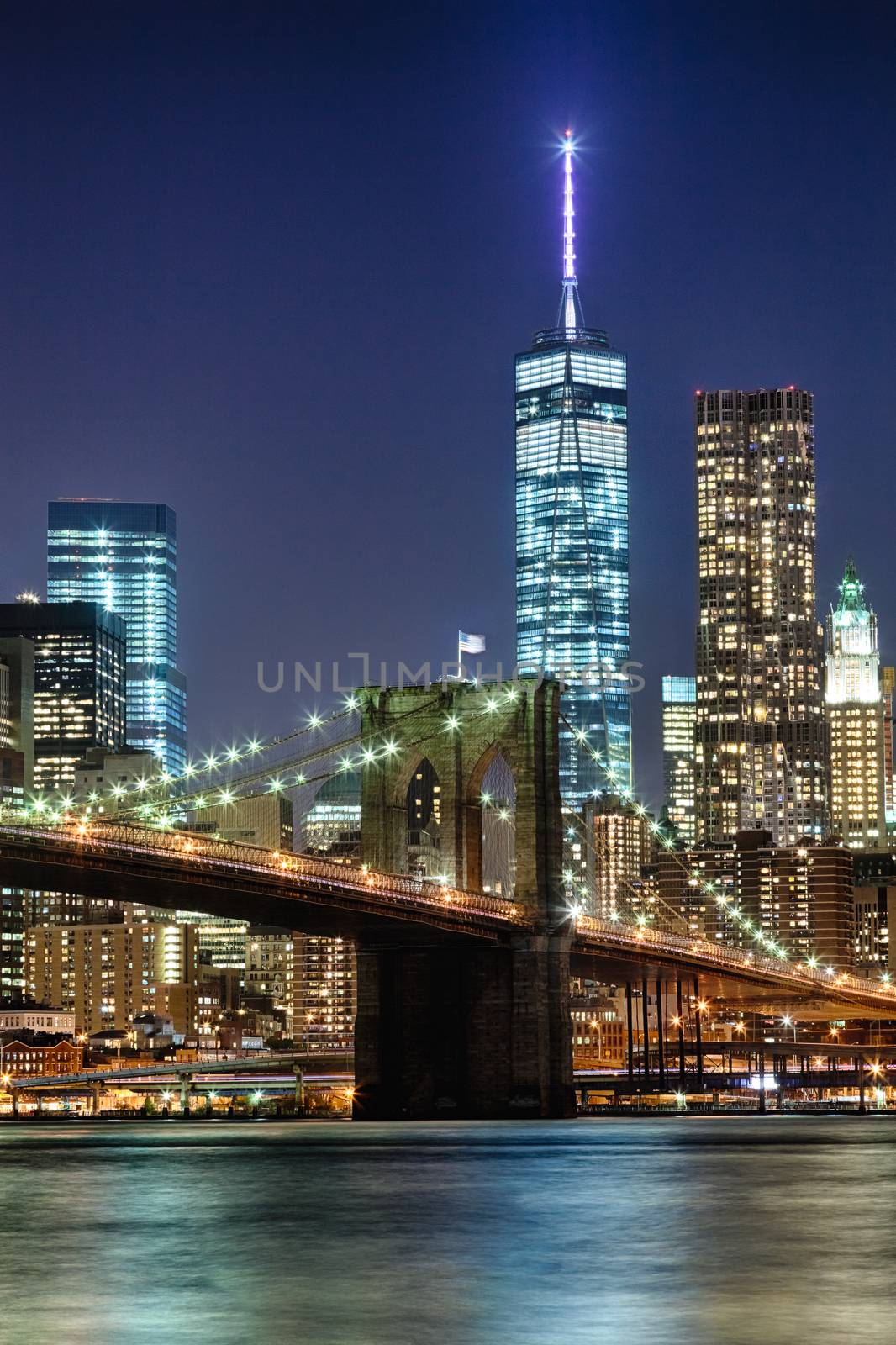 The New York City skyline at night w Brooklyn Bridge and Freedom tower