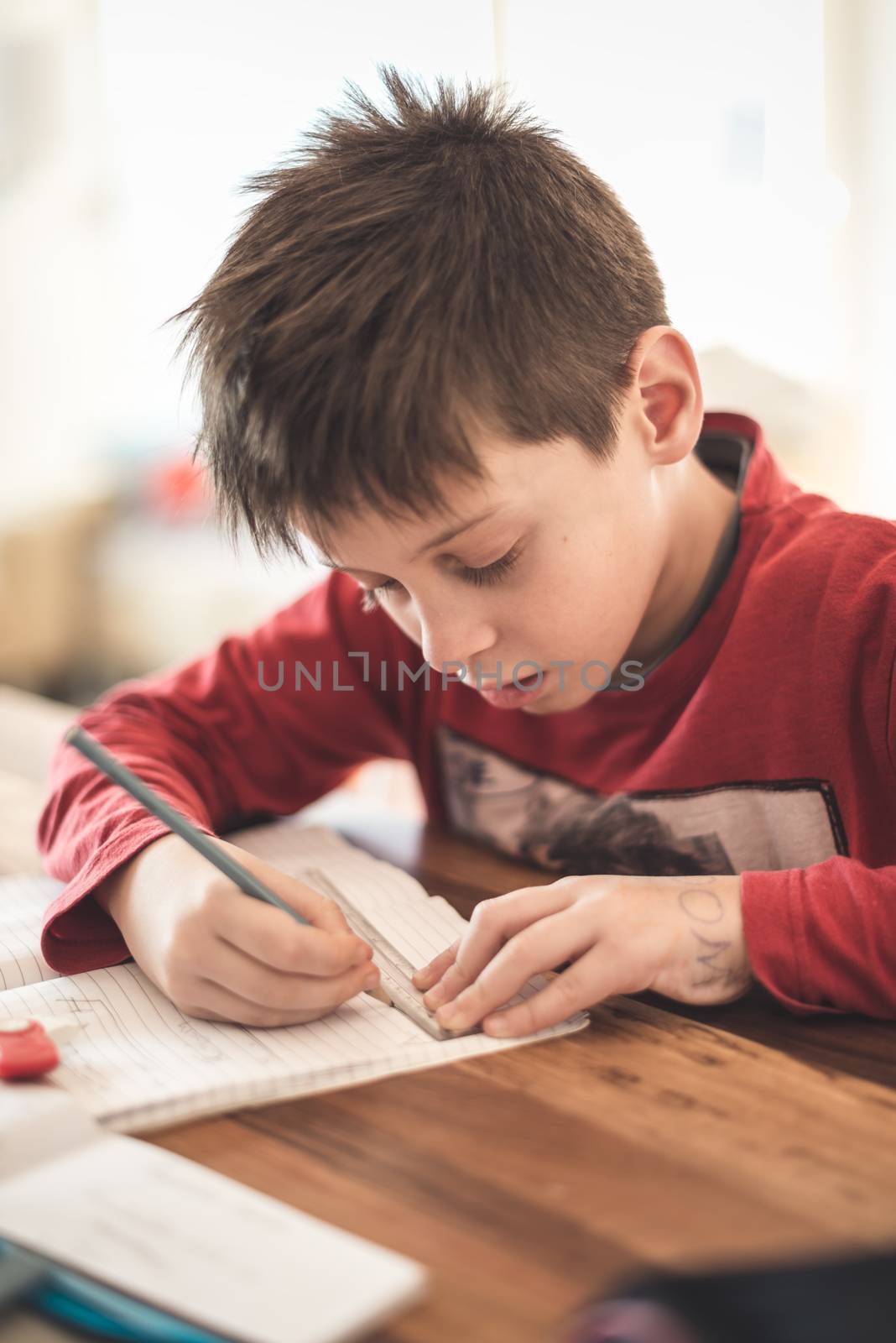 Young boy doing homework from mathematics at home