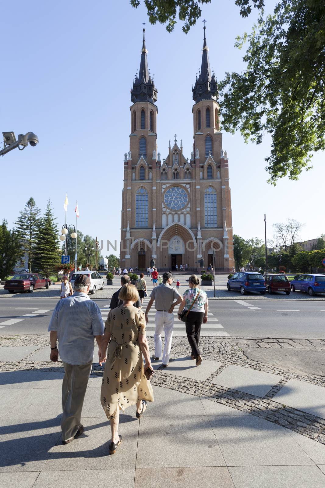 RADOM CITY, POLAND - August 8, 2014: Unidentified people walk in front of Catholic cathedral of the Protection of the Blessed Virgin Mary in Radom, Poland