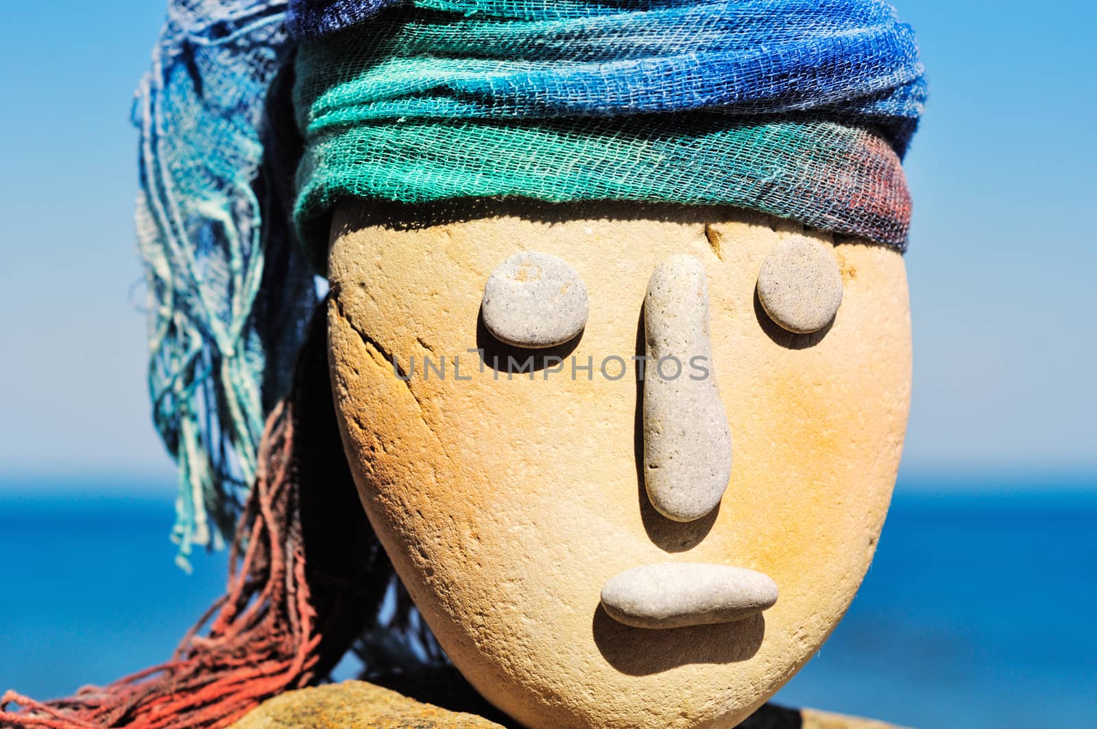 Image of stone head with a coloured bandana