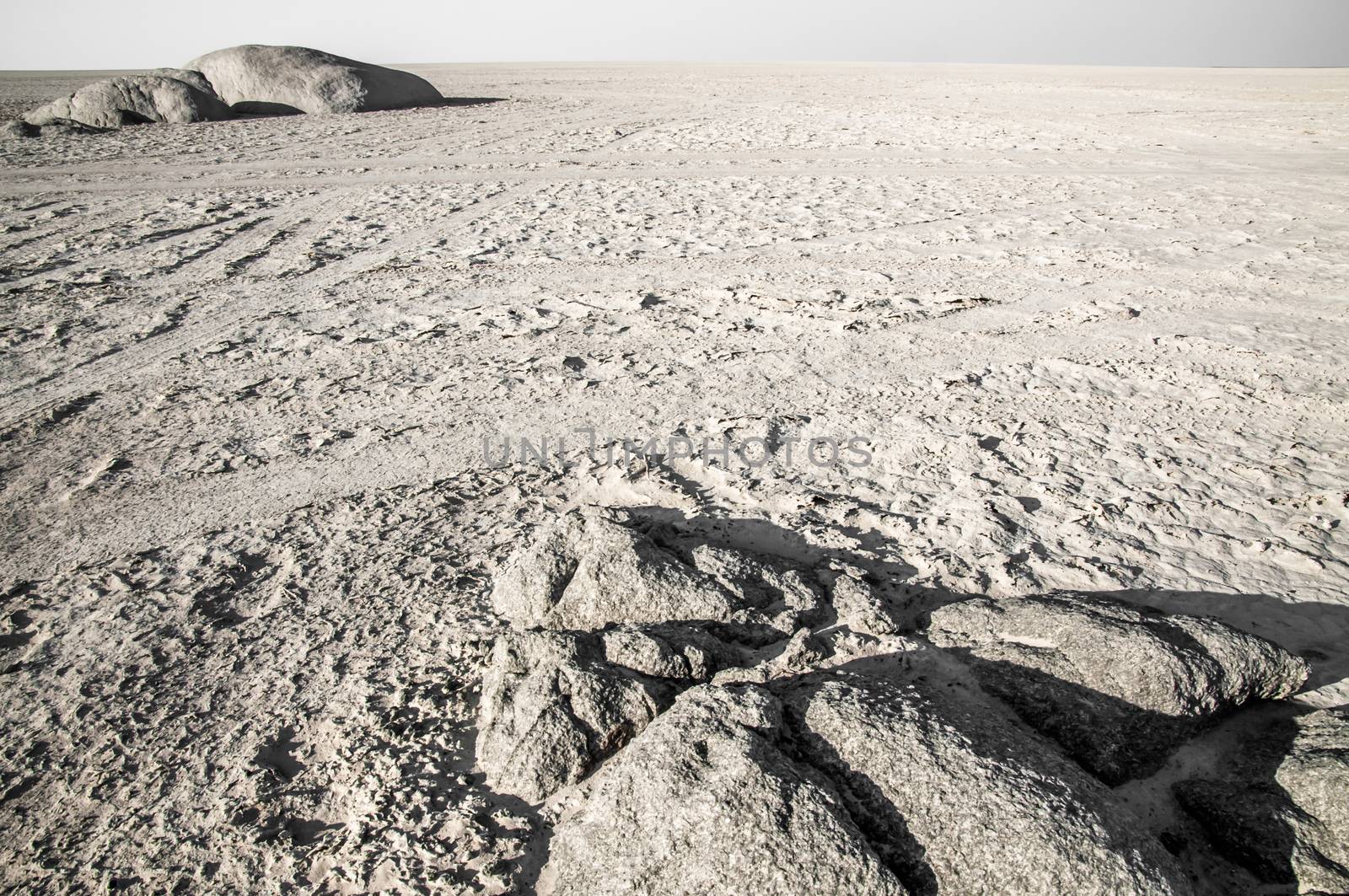Rocks cropping out in a barren salt pan landscape in Botswana.
