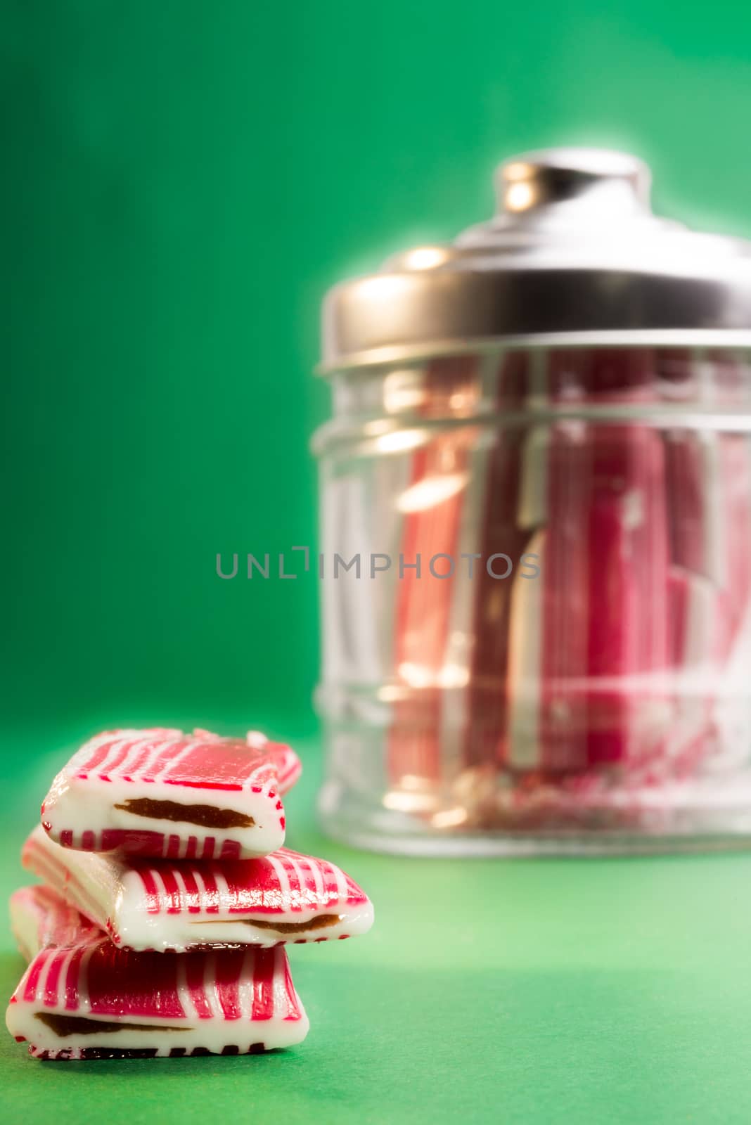 Candy on a green background, with the bottle in the background.