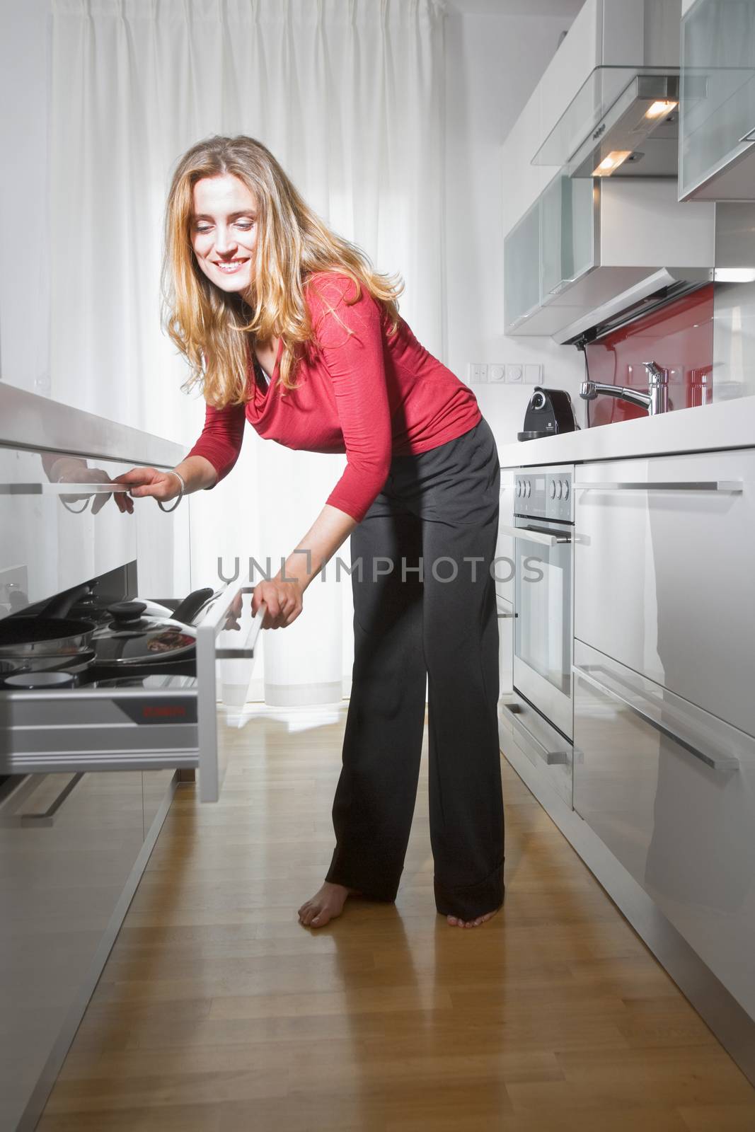 young beautiful woman standing in modern kitchen interior