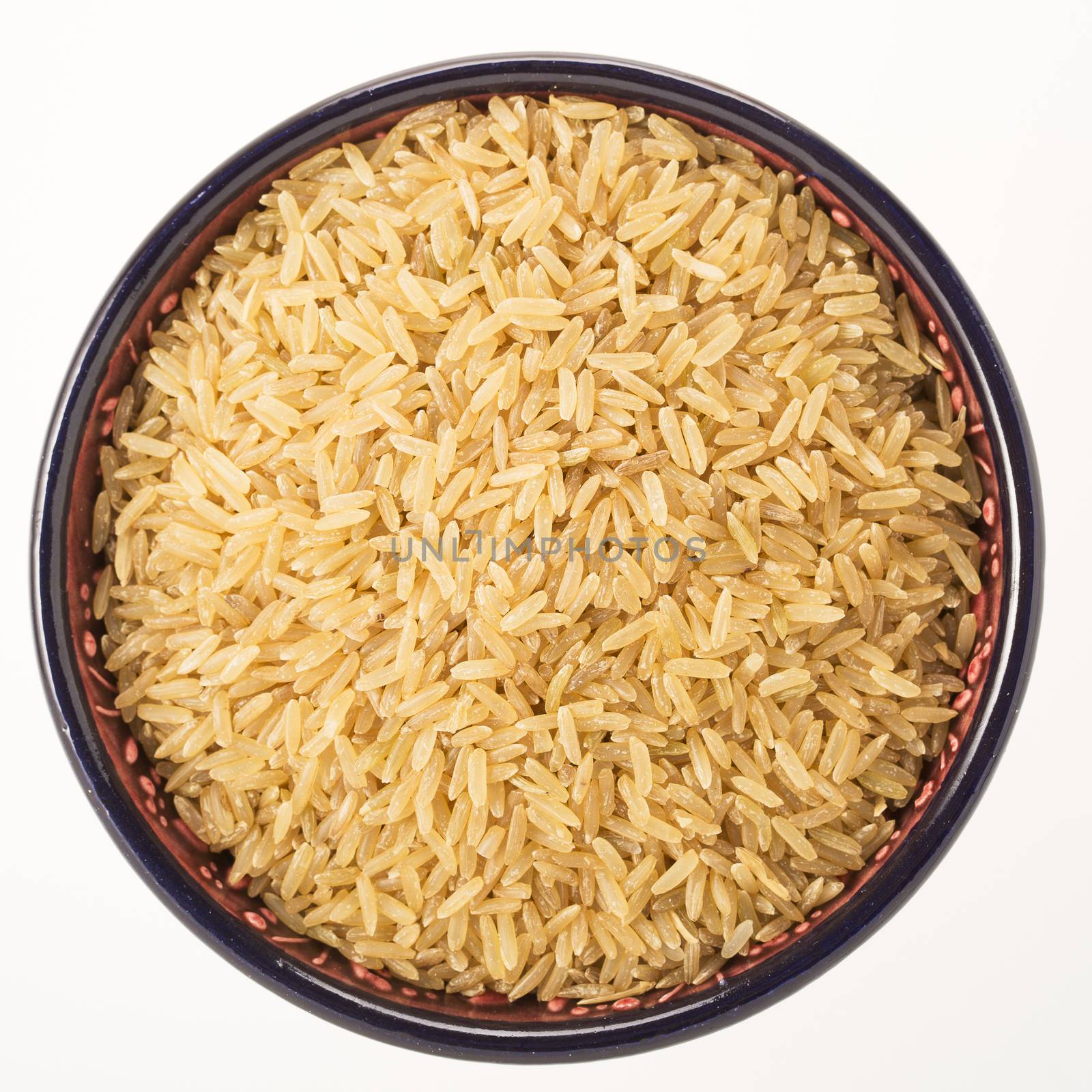 Brown rice in bowl isolated on white background