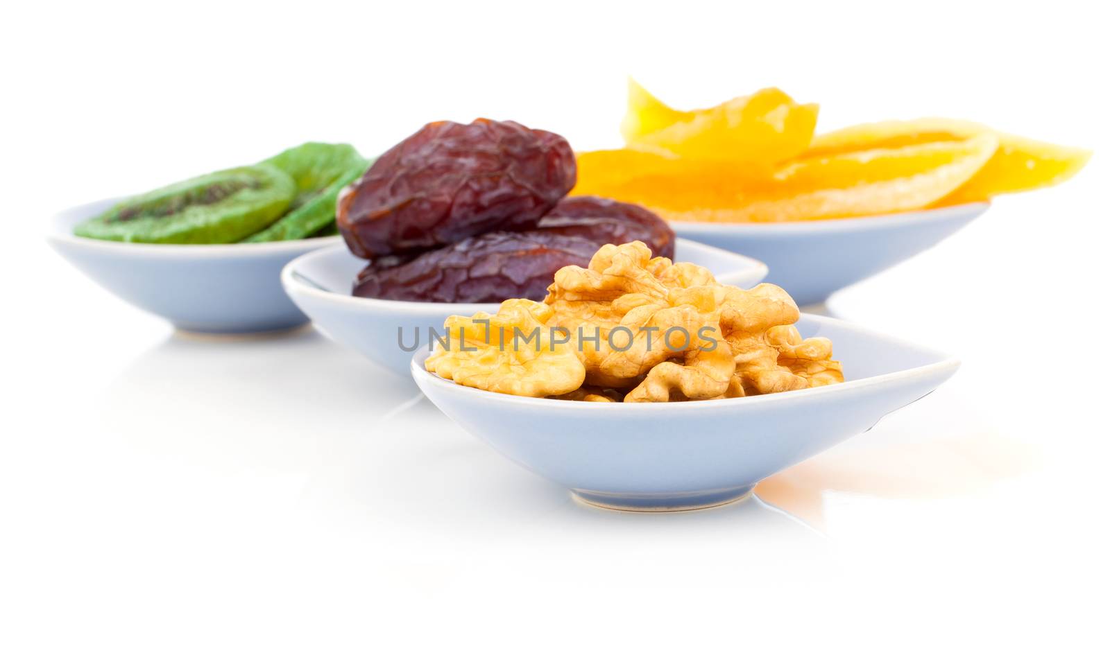 dry fruits pile against in bowl on white background by motorolka