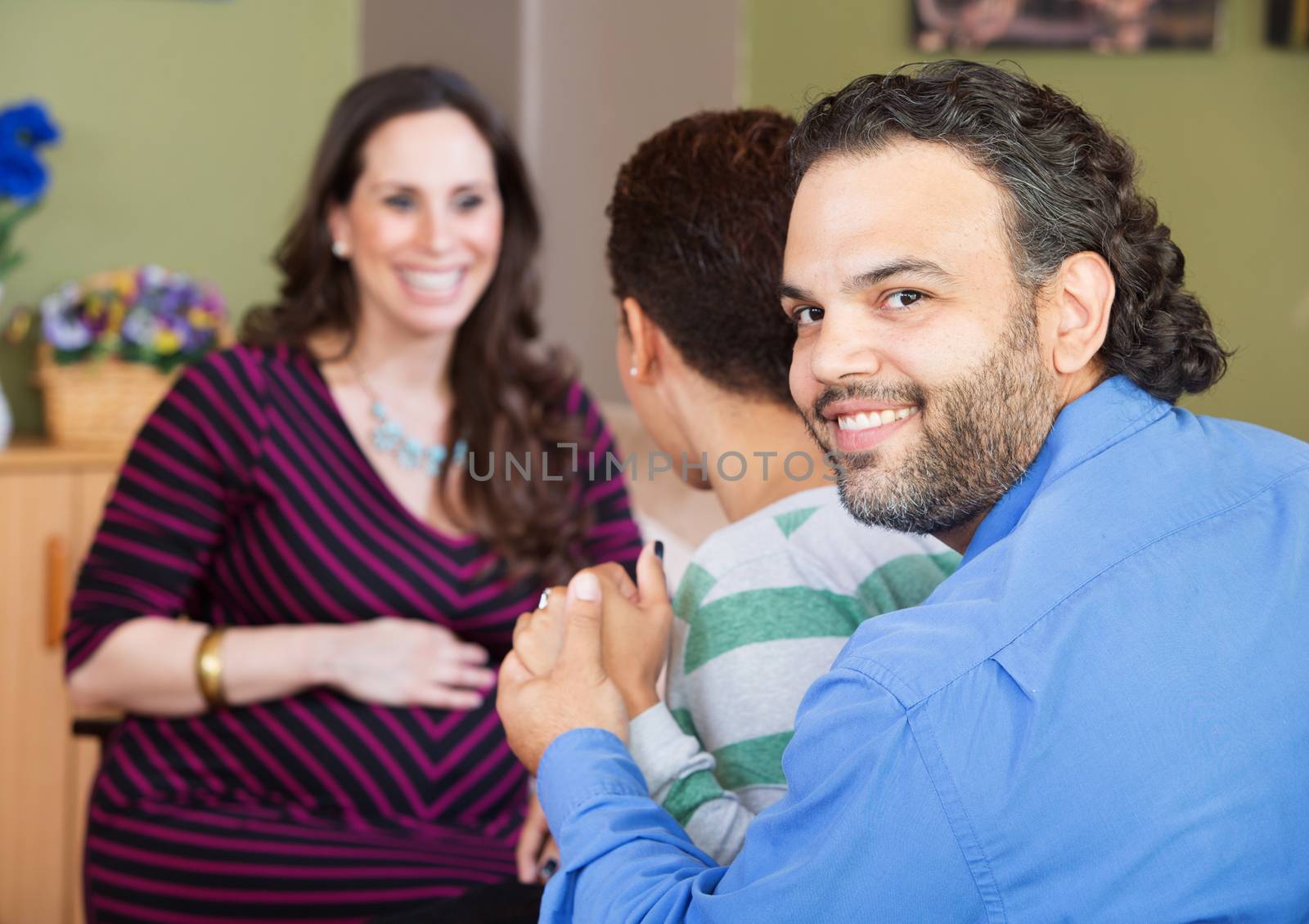 Smiling Latino man with wife and surrogate mother