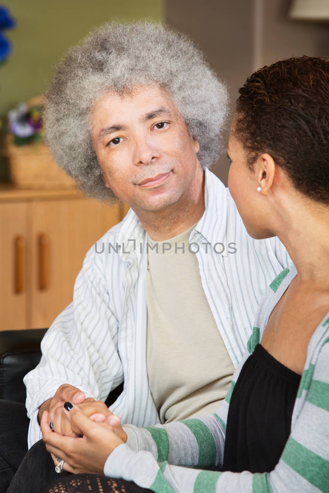Calm handsome Black man holding hand of woman