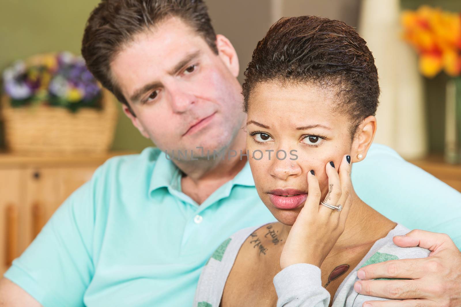 Worried mixed Black and White couple sitting together