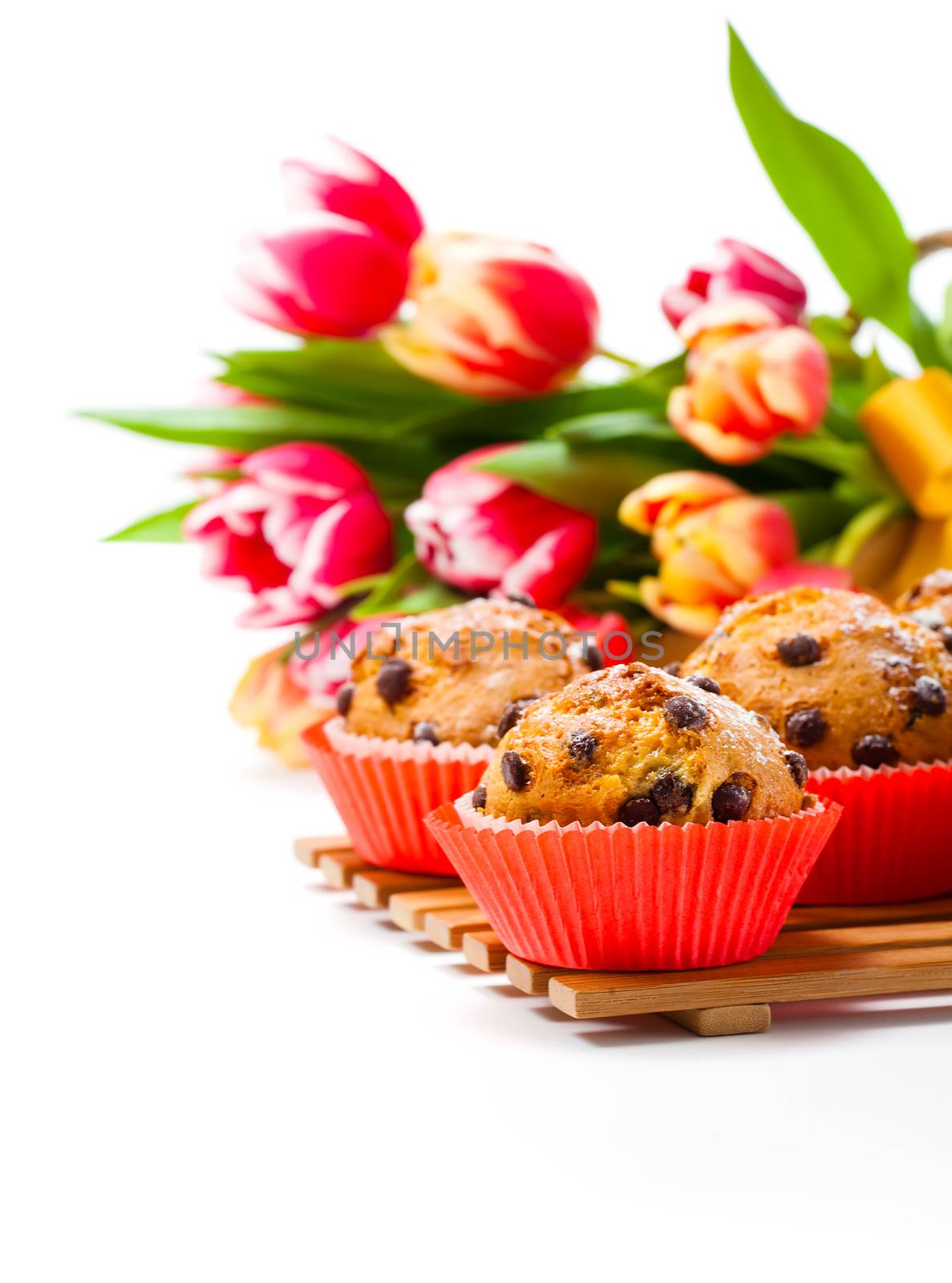 homemade cupcakes with spring tulips. Isolated on white.