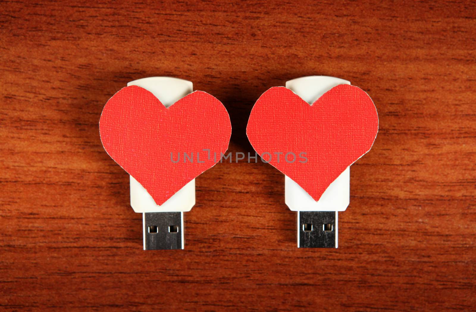 Two USB Flash Drive with Heart Shapes on the Wooden Background