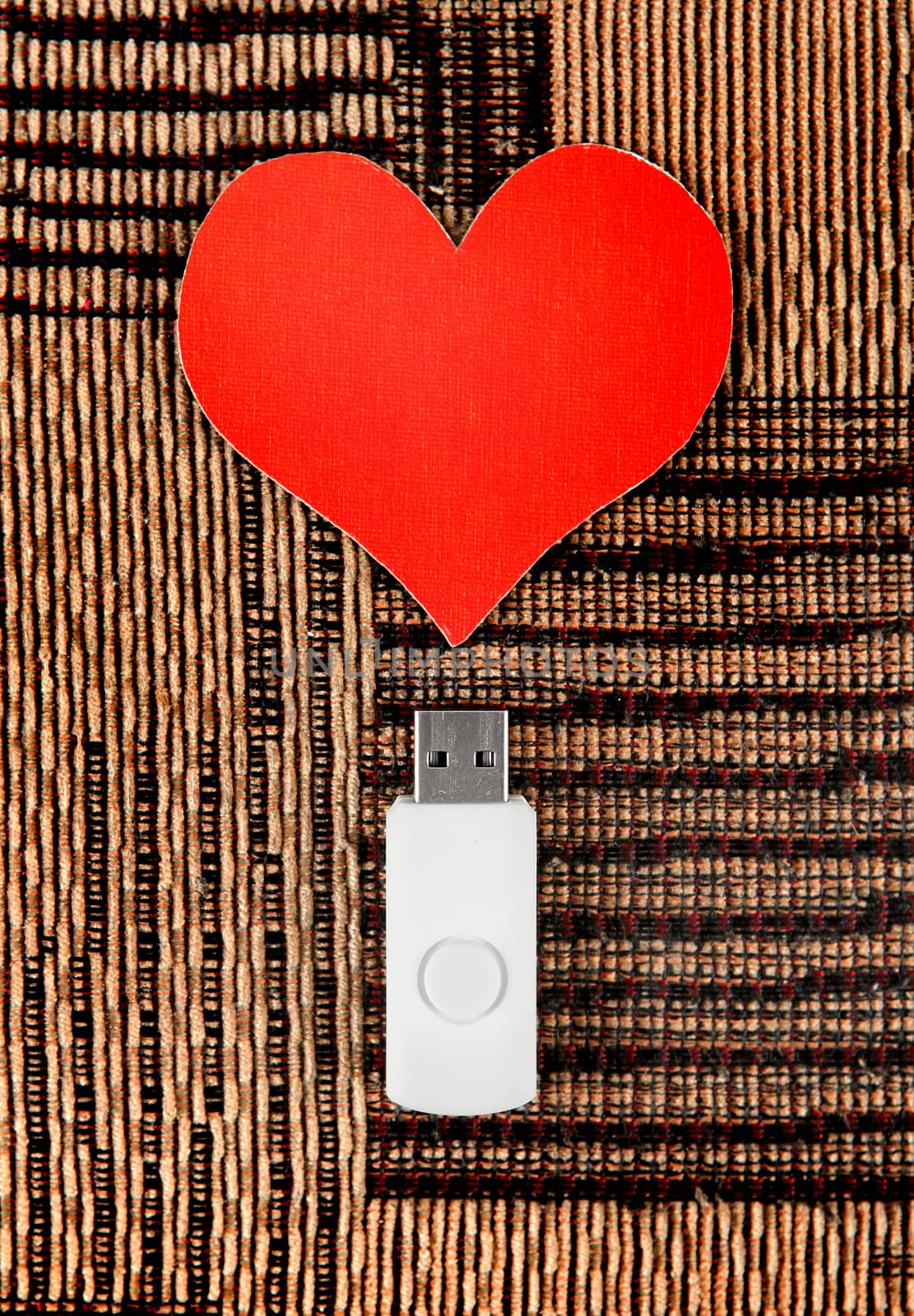 USB Flash Drive with Heart Shape on the Fabric Background