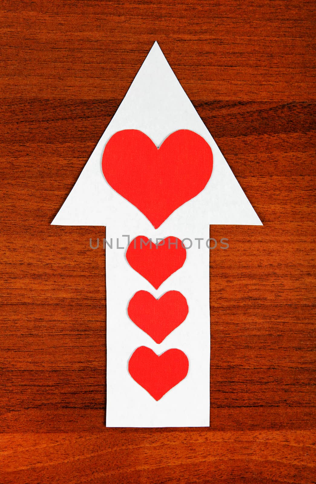 Red Heart Shapes on the Arrow and on the Wooden Background