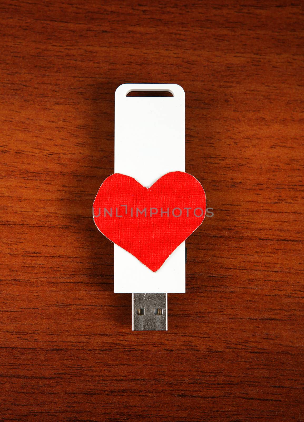 USB Flash Drive with Heart Shape on the Wooden Background