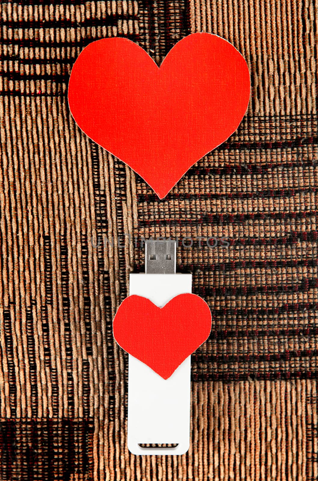 USB Flash Drive with Heart Shape on the Fabric Background