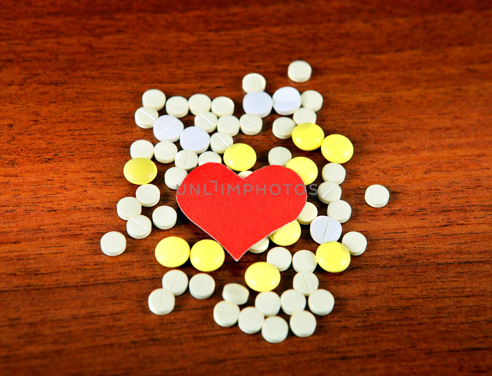 Heart Shape with the Pills on the Wooden Background