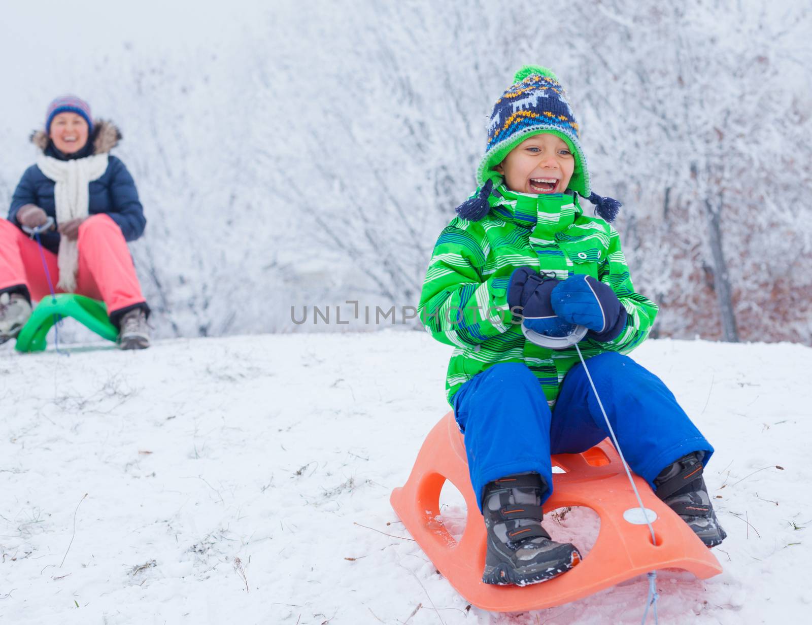 Winter, play, fun - Cute little boy having fun with sled in winter park