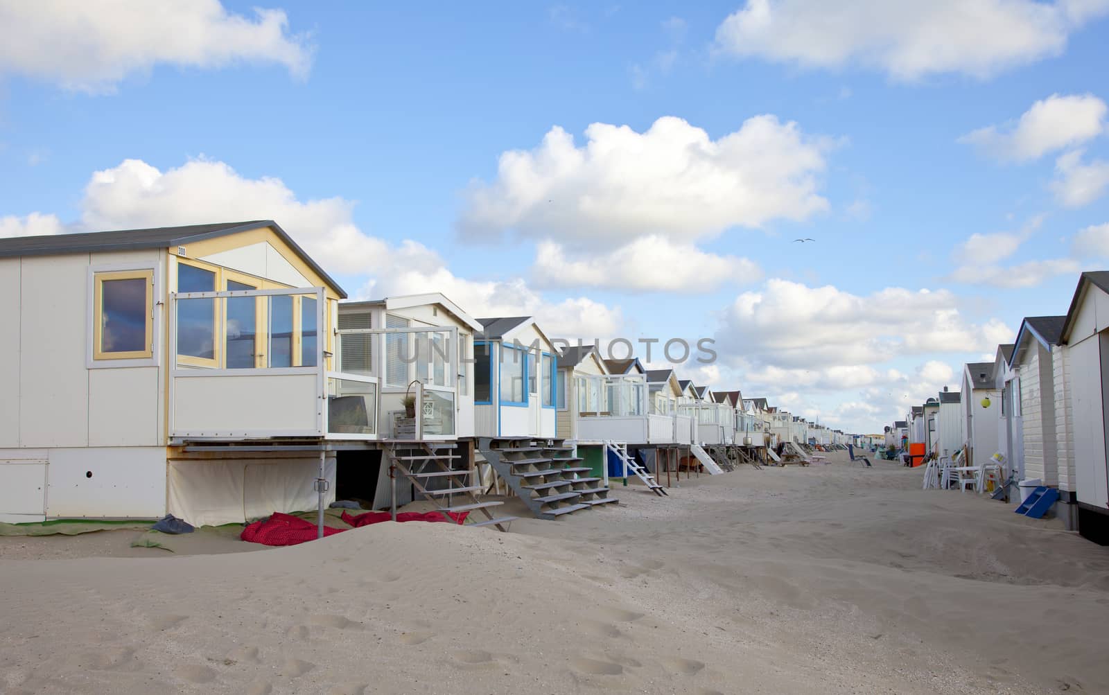 Beach houses on beach in a row with blue sky