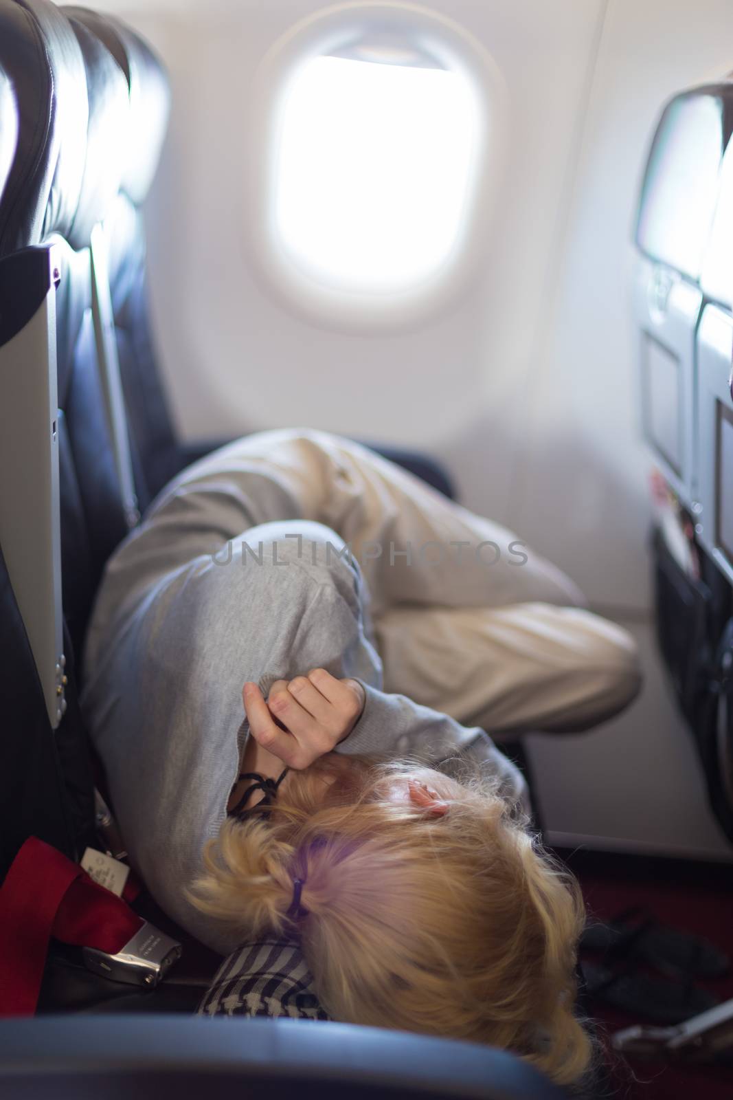 Woman sleeping during flight aboard a jetliner airplane.