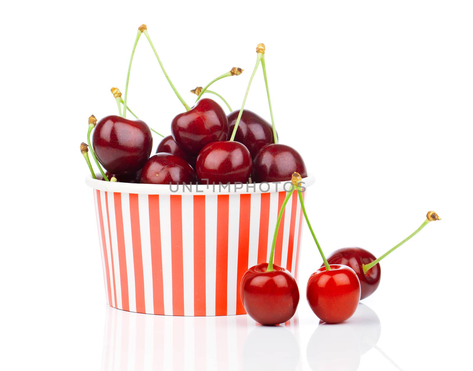 fresh cherry berries in striped bucket on white background