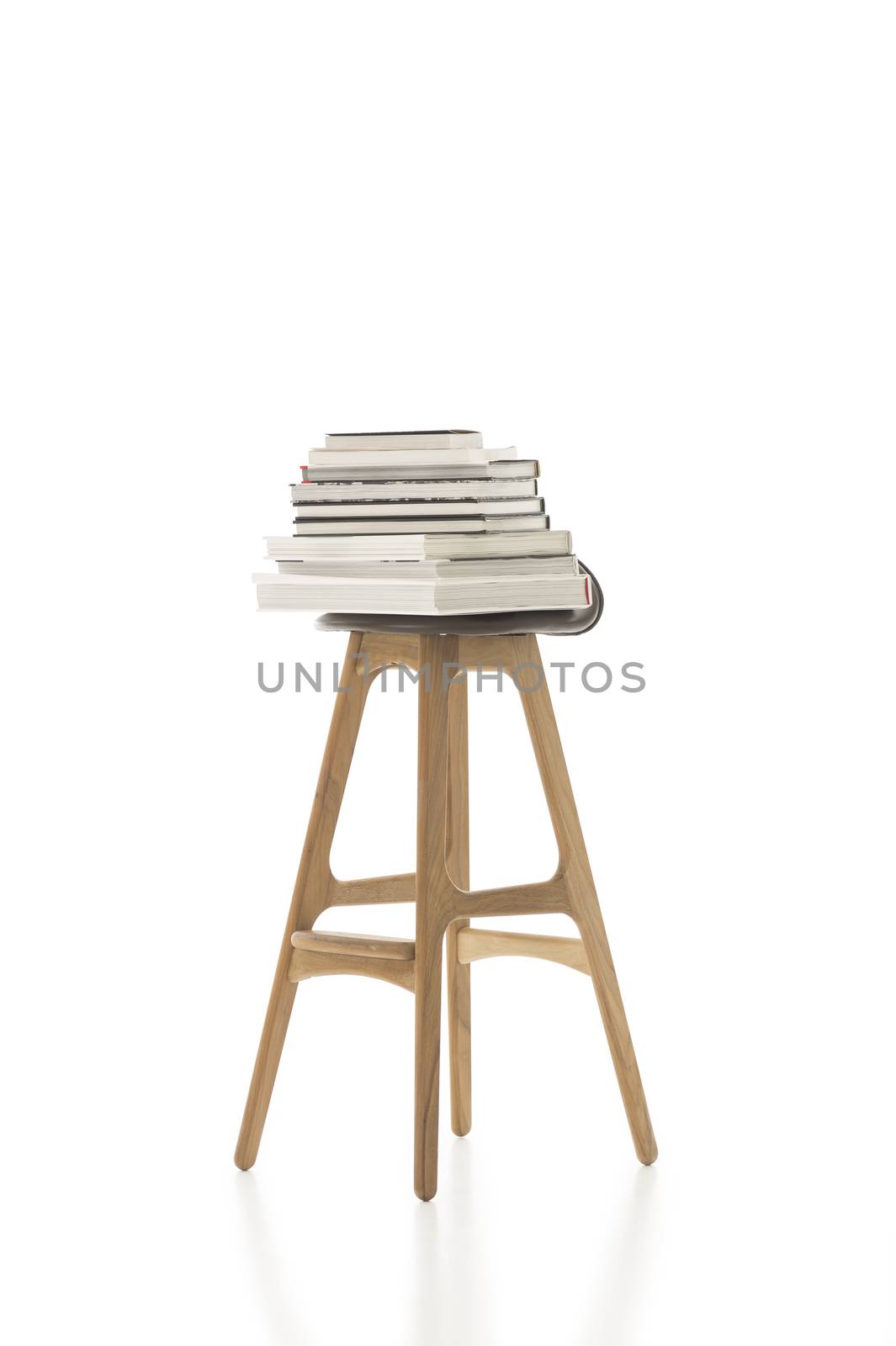 Piled Books on Top of Tall Single Chair by MOELLERTHOMSEN