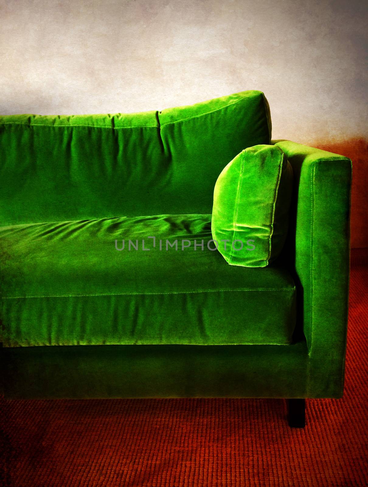 Green velvet retro sofa in a room.