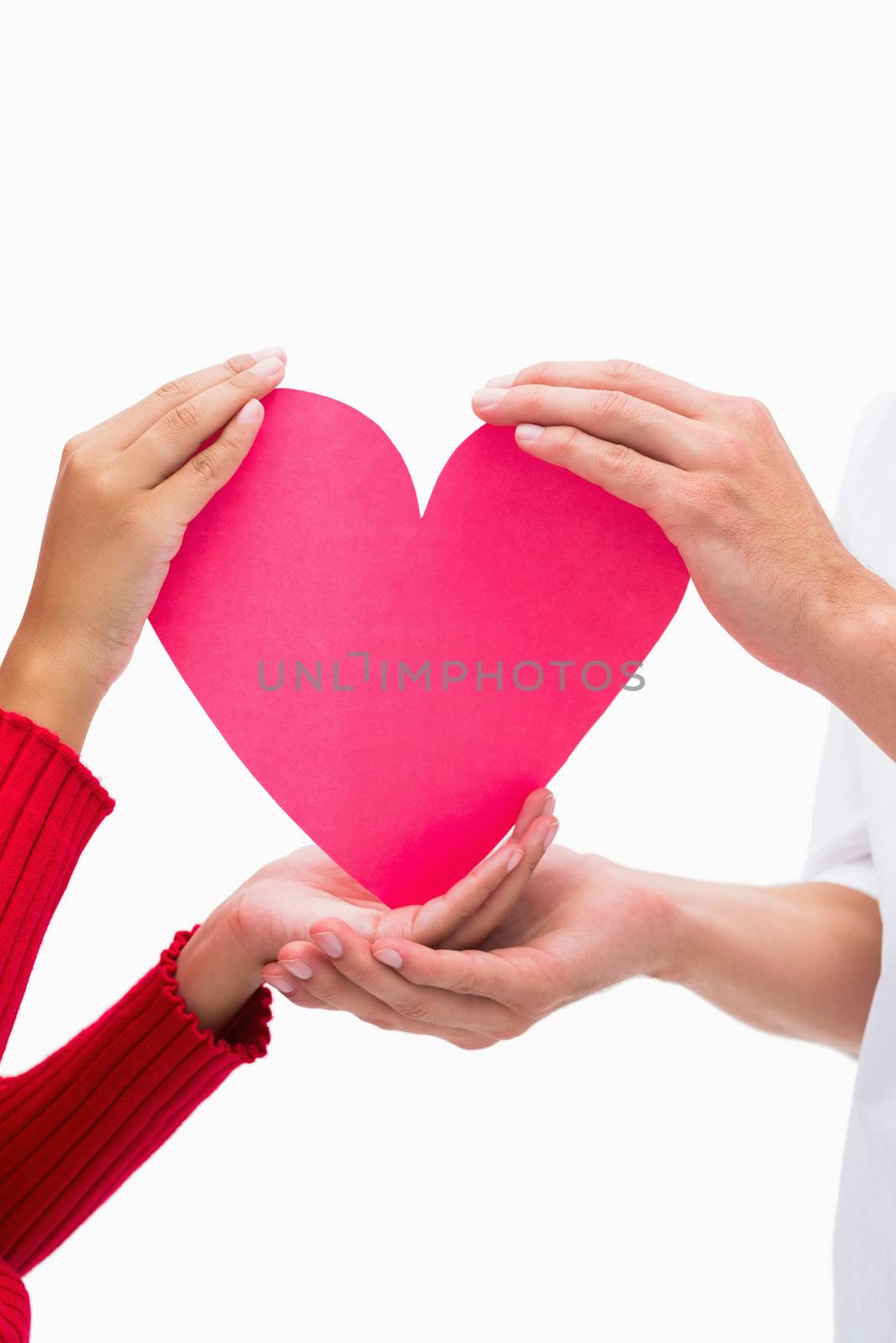 Couples hands holding pink heart by Wavebreakmedia