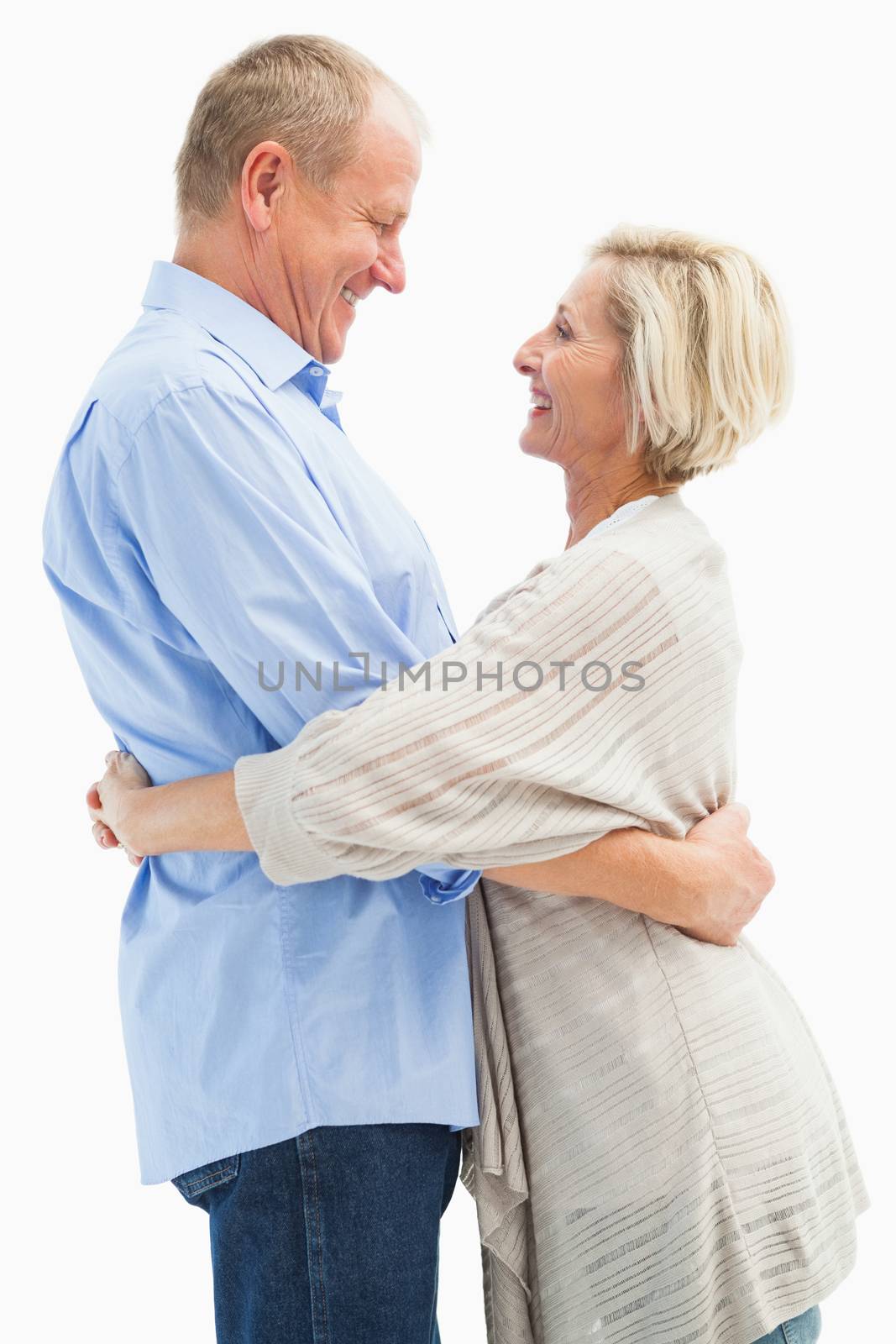 Happy mature couple hugging and smiling on white background
