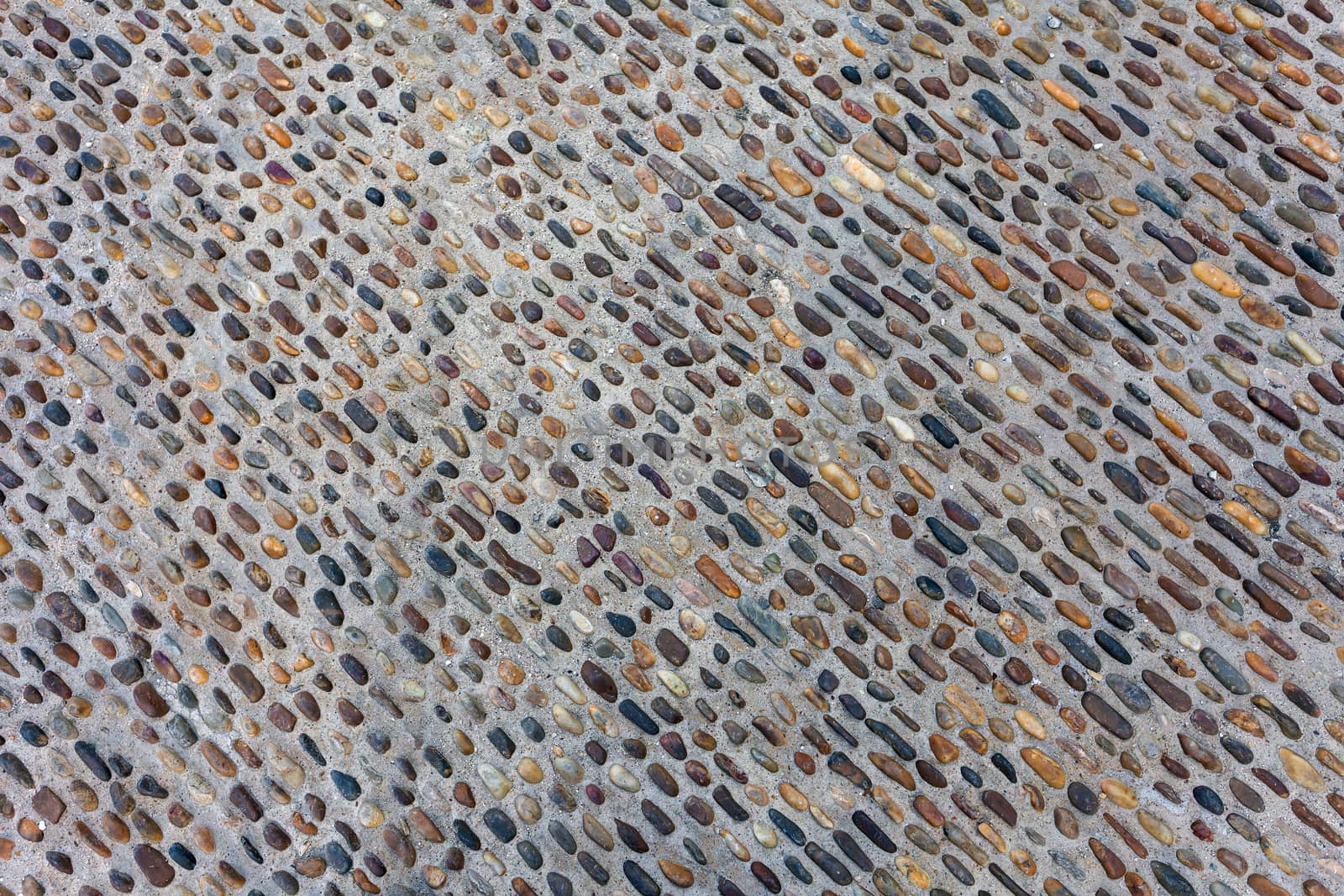Seamless tile background made of small stones (pebbles) on sidewalk or wall