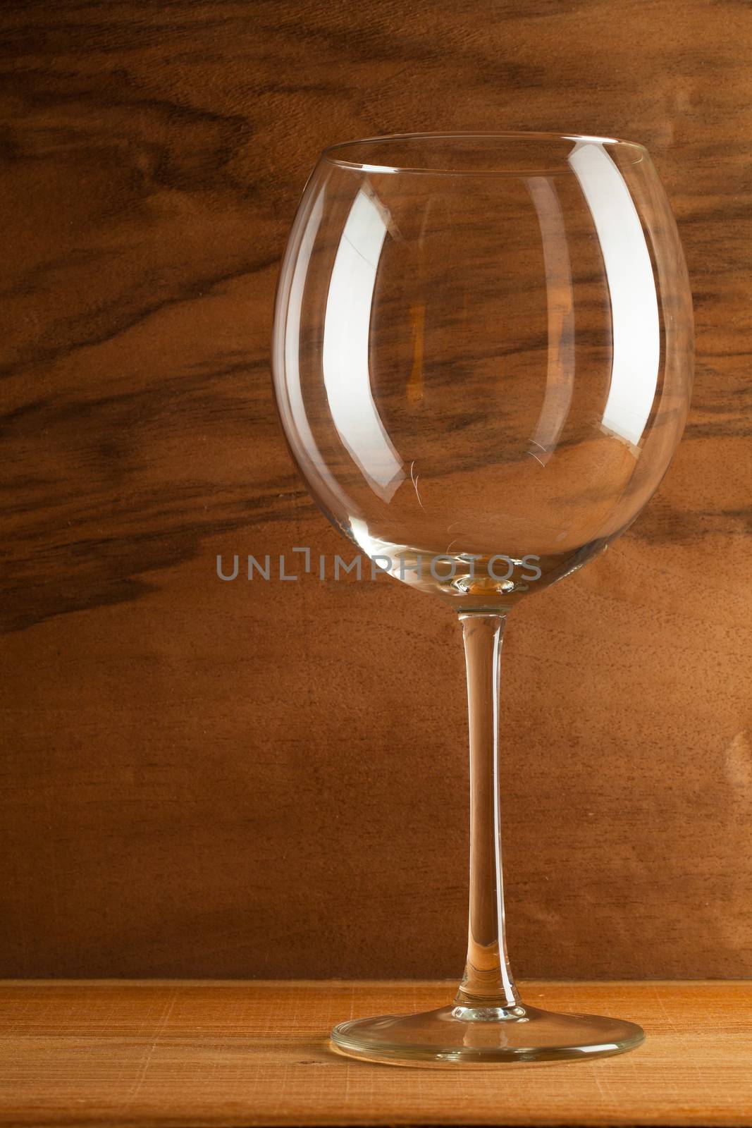 Glass of wine on the wooden background from real wood veneer with interesting growth