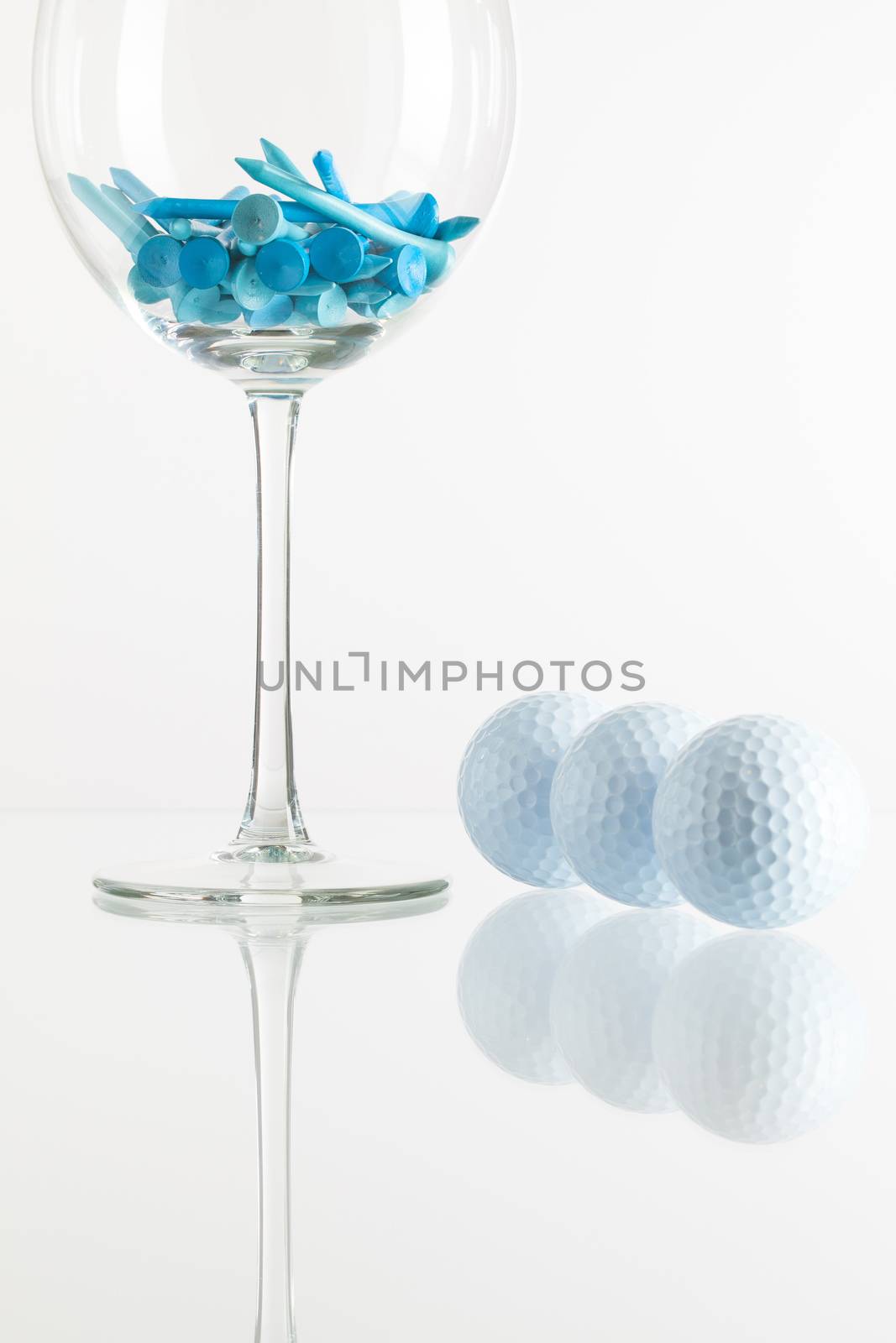 Glass of wine and golf equipments by CaptureLight