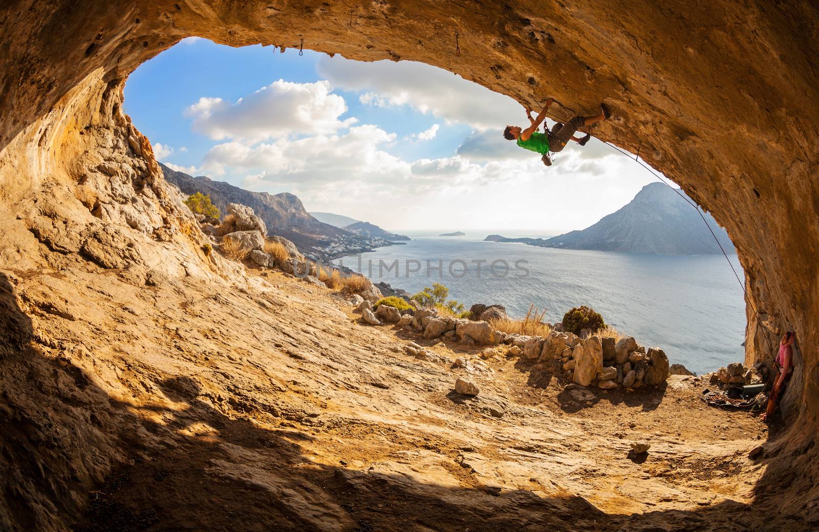 Young man lead climbing in cave by photobac