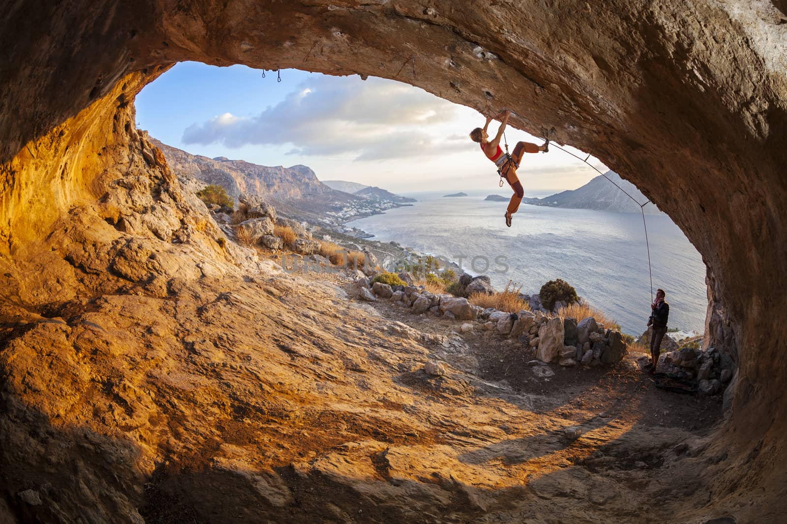 Young woman lead climbing in cave by photobac