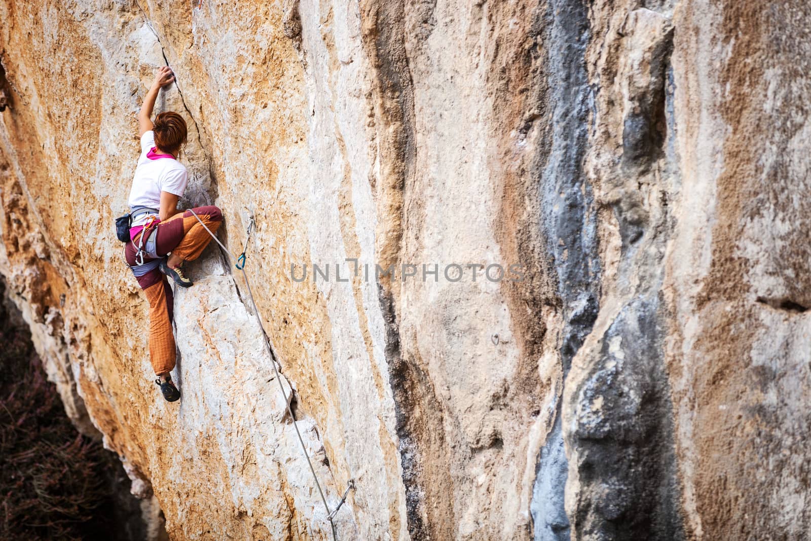 Young female rock climber on a cliff face