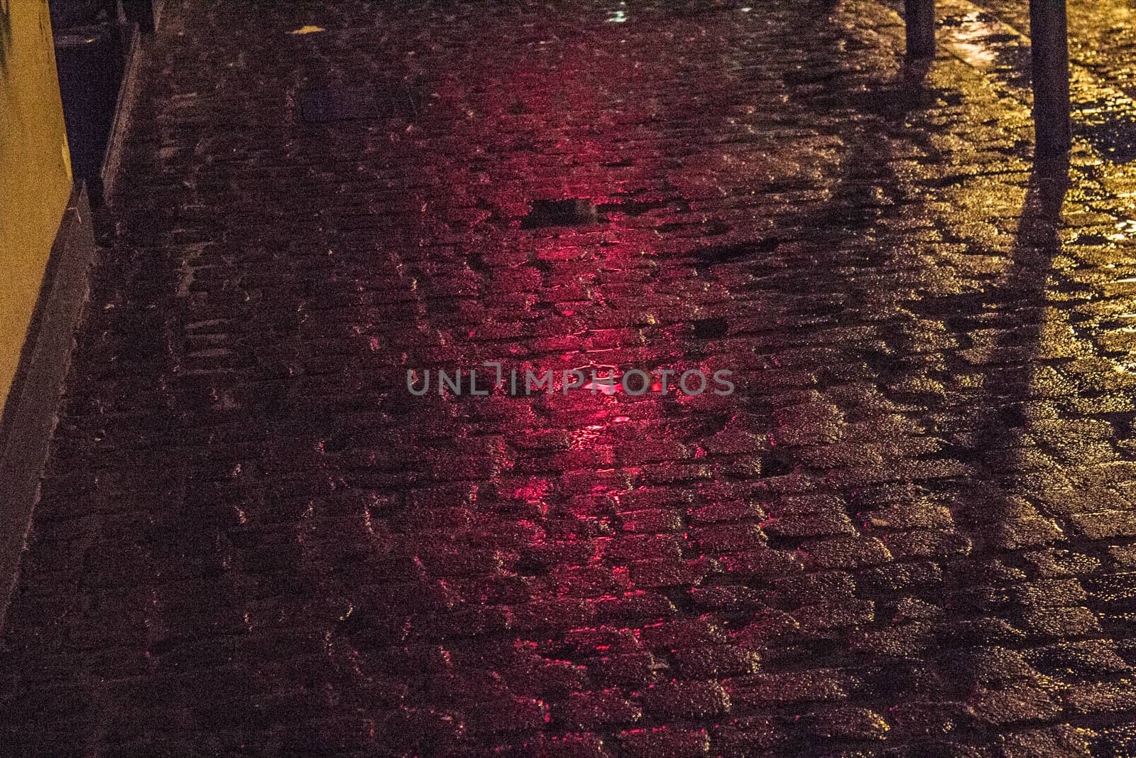 Close-up pedestrian street in the night, with orange and red light