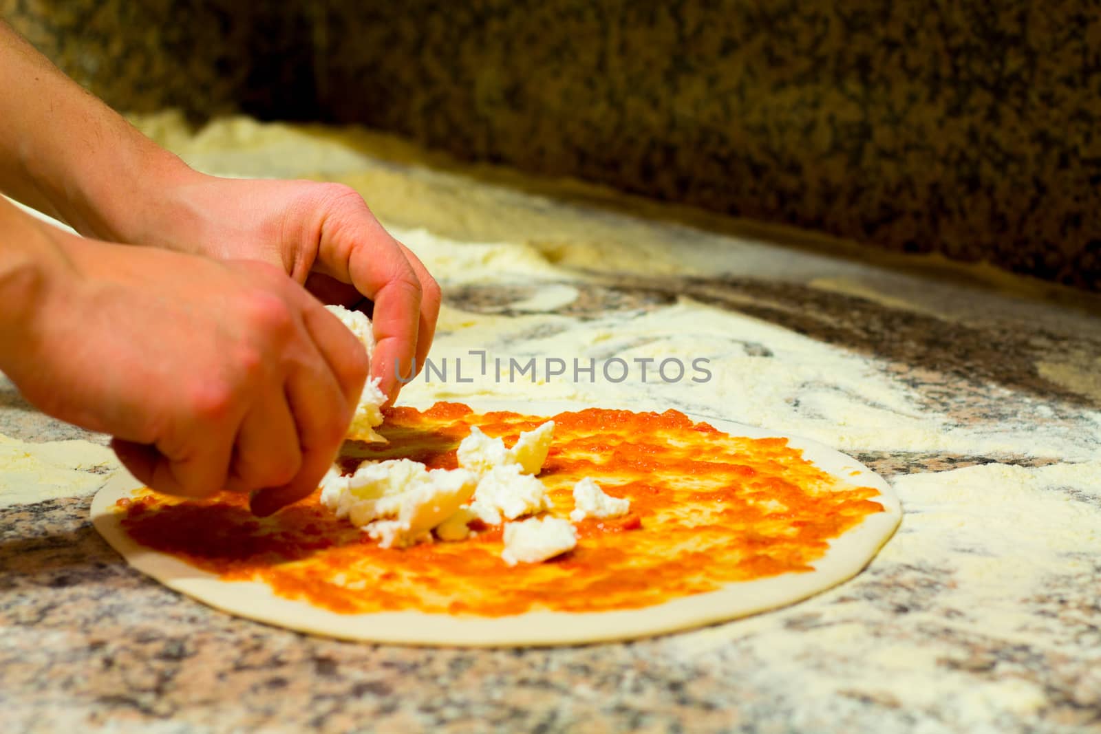 Spread cheese in the pizza whit tomato sauce