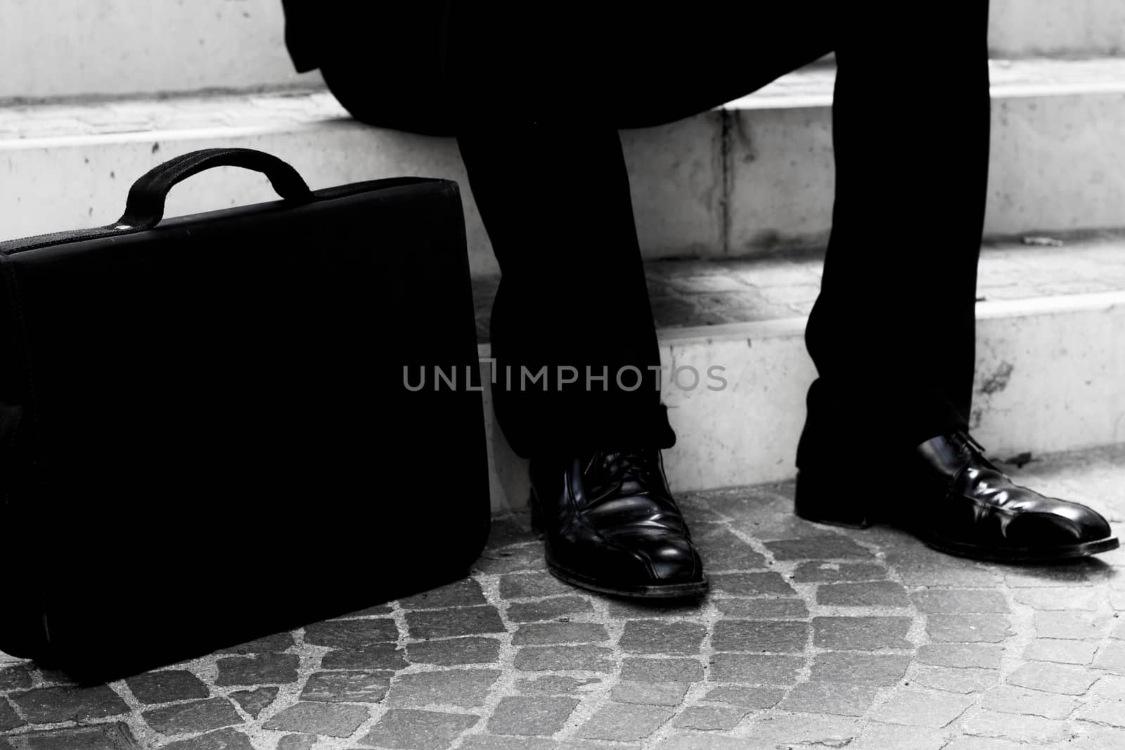 the business man sitting in the stairs outdoor