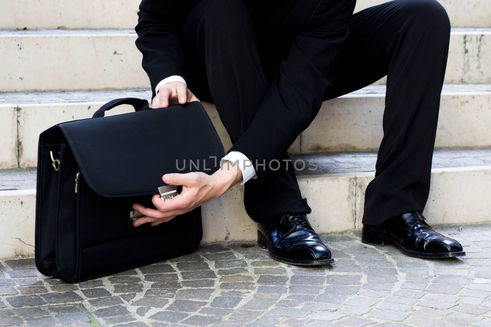 man sitting in the stairs open the professional bag