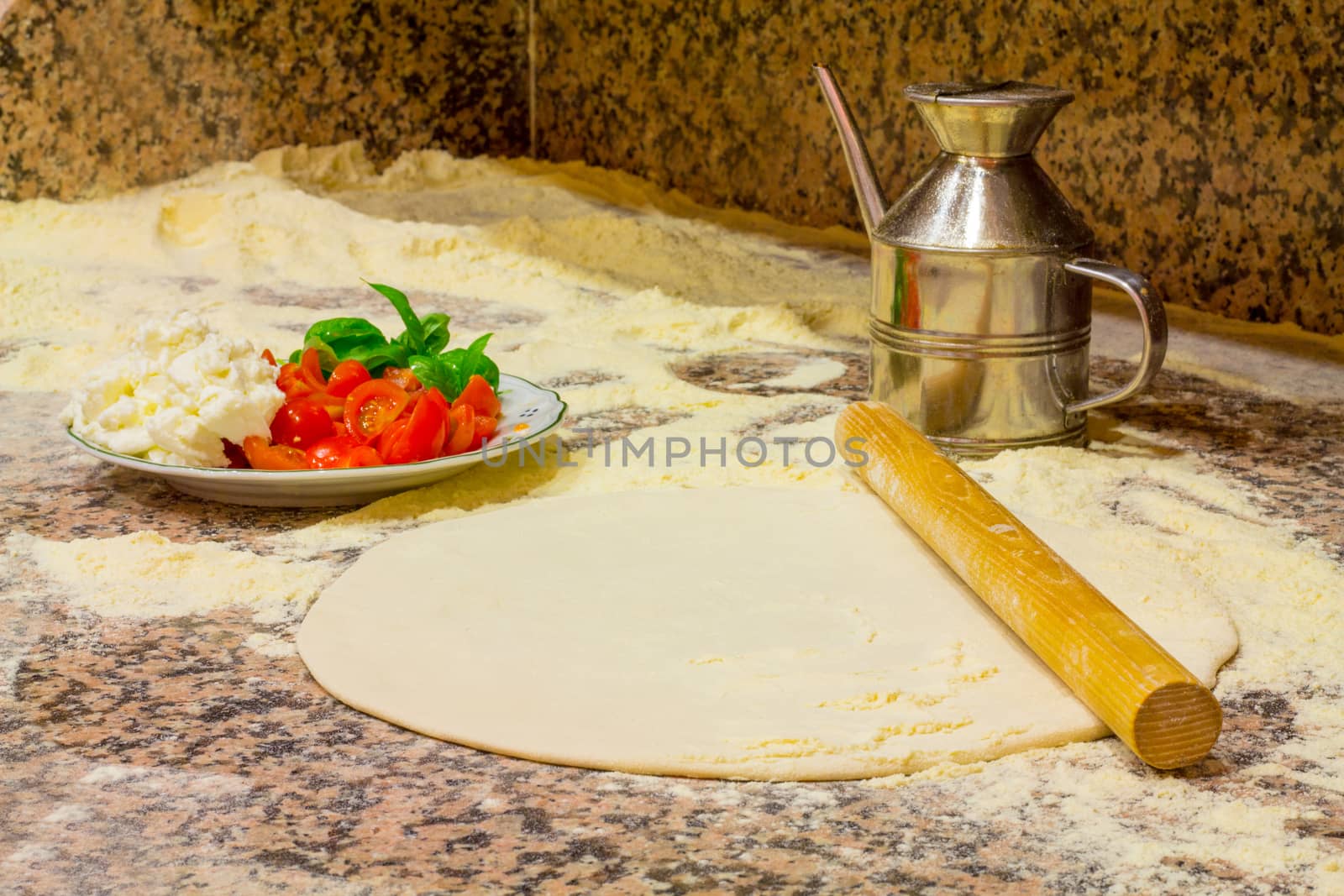 Make a typical italian food, dough, cheese, tomato, basil, flour