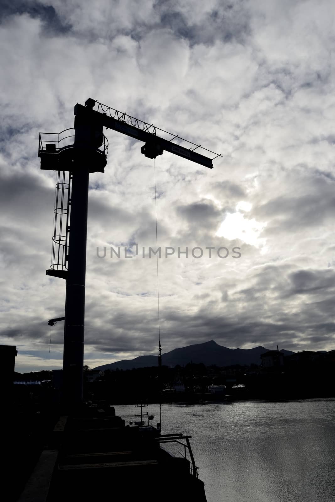 silhouette of a crane in a harbor by ncuisinier